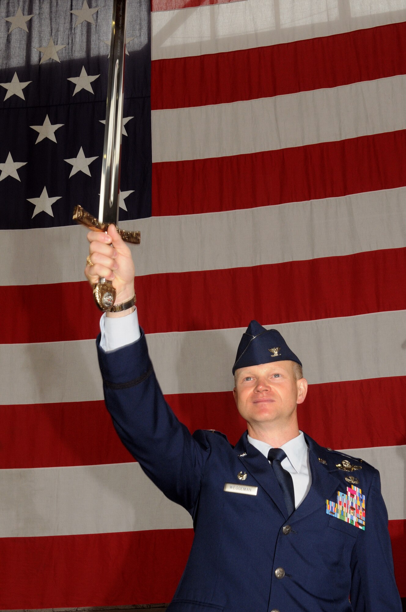 SPANGDAHLEM AIR BASE, Germany -- Col. Christopher Weggeman, 52nd Fighter Wing commander, holds the 52nd Fighter Wing saber in the air before chanting “seek, attack, destroy and deter,” the 52nd FW chant.  The saber was a gift to the wing from Col. Tip Wight, the former 52nd FW commander.  (U.S. Air Force photo/Staff Sgt. Logan Tuttle)
