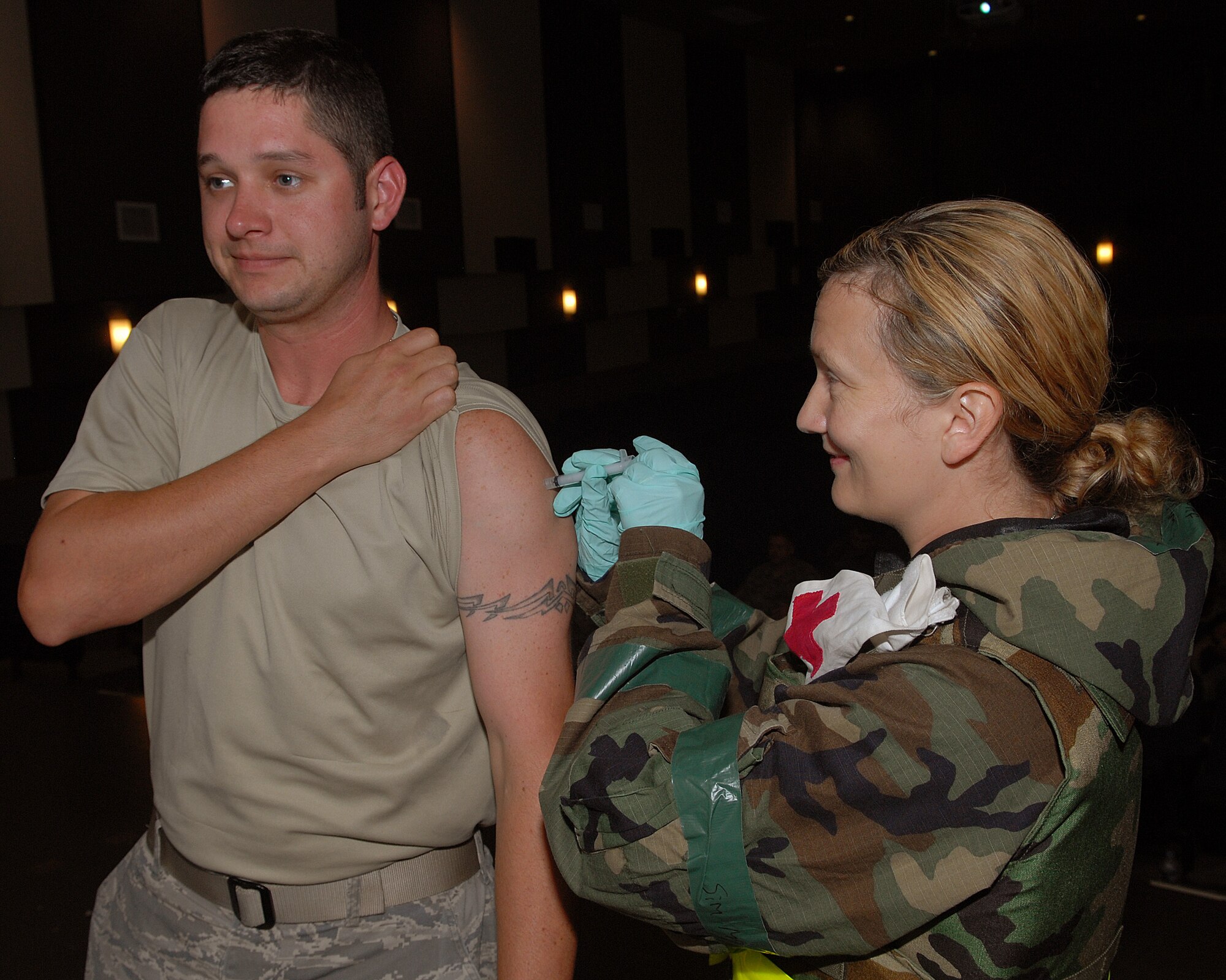 KUNSAN AIR BASE, Republic of Korea -- Tech. Sgt. Amy Glover, 35th Fighter Squadron, gives Staff Sgt. John McNiel, 80th Aircraft Maintenance Unit, an immunization shot during a Personnel Deployment Reception Function here July 13. PDRF is a quick way to in process and give information to follow on forces, to take the fight north. (U.S. Air Force photo/Senior Airman Roy Lynch)