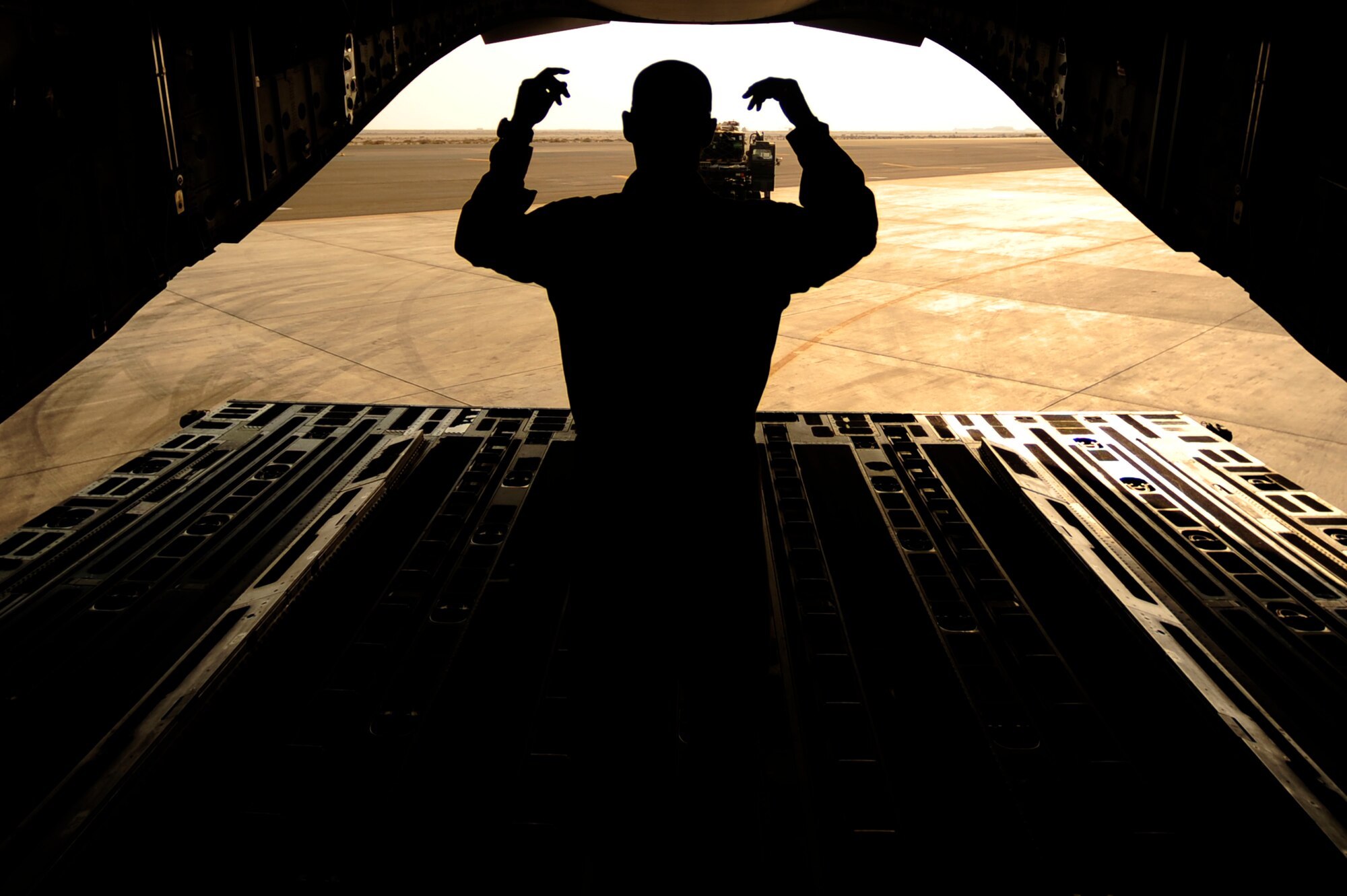 U.S. Air Force Airman First Class, Brian Whitcomb, a C-17 Globemaster III loadmaster assigned to the 816th Expeditionary Airlift Squadron, guides in an equipment truck during an on load of cargo in Baghdad, Iraq, while deployed to an undisclosed location in Southwest Asia on July 6, 2010. (U.S. Air Force photo by Staff Sgt. Andy M. Kin / Released)