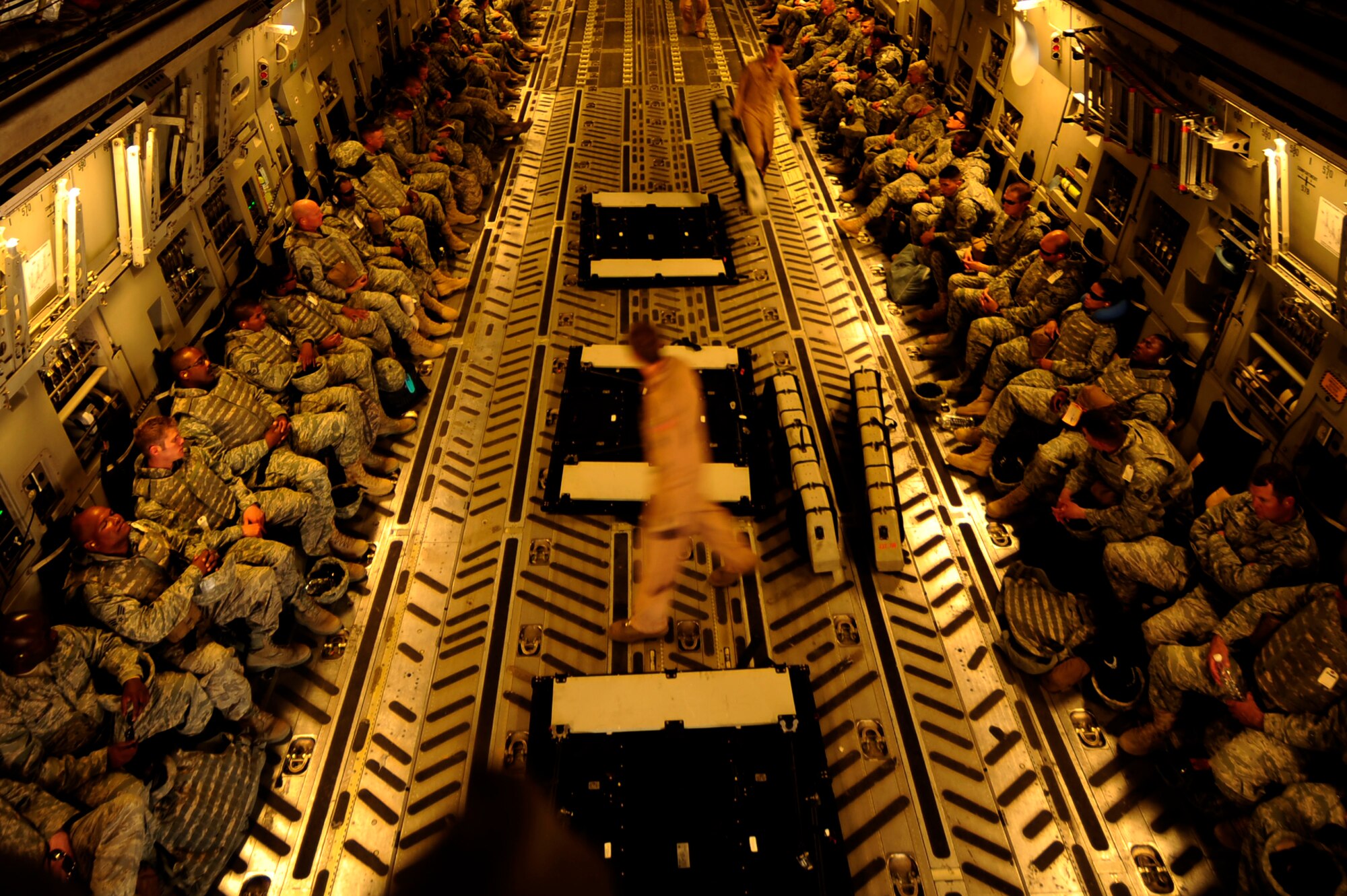 U.S. Air Force loadmasters, assigned to the 816th Expeditionary Airlift Squadron, secure a center row of seating during a full passenger load aboard a C-17 Globemaster III aircraft while deployed to an undisclosed location in Southwest Asia on July 6, 2010.  (U.S. Air Force photo by Staff Sgt. Andy M. Kin / Released)