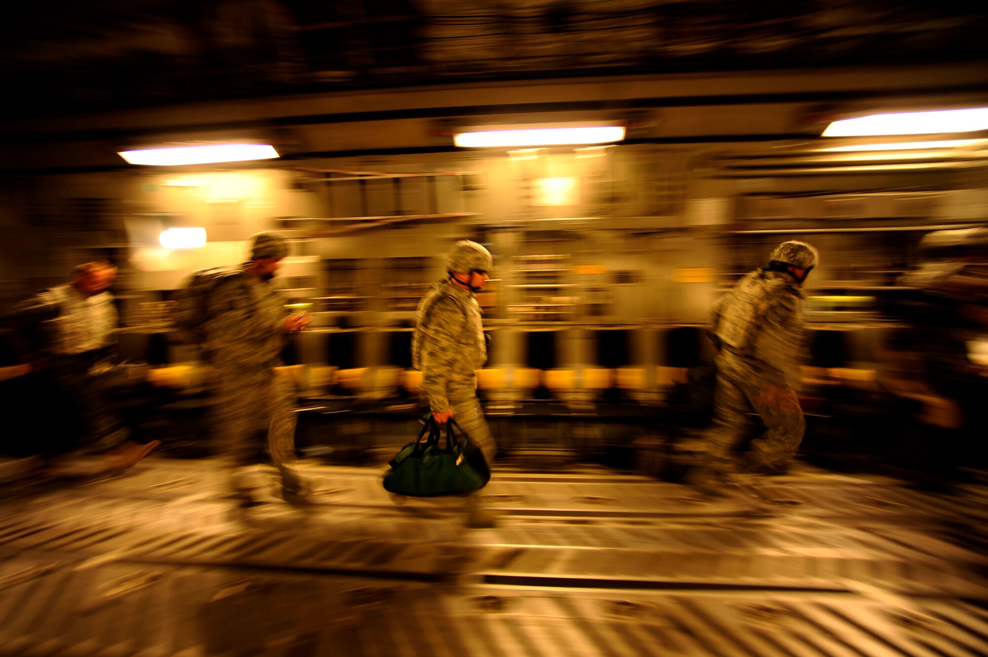 U.S. Air Force Airmen, aboard a C-17 Globemaster III aircraft, assigned to the 816 Expeditionary Airlift Squadron, grab their gear and head for the exit during a flying mission from an undisclosed location in Southwest Asia to Baghdad, Iraq on July 6, 2010.  (U.S. Air Force photo by Staff Sgt. Andy M. Kin / Released)