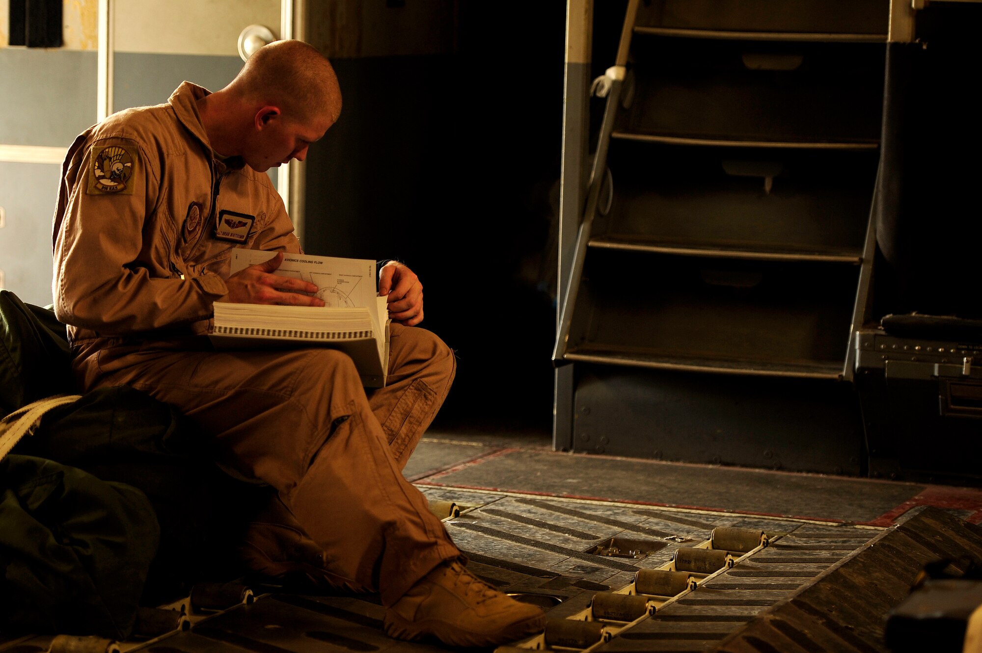 U.S. Air Force Airman First Class, Brian Whitcomb, a C-17 Globemaster III loadmaster assigned to the 816th Expeditionary Airlift Squadron, looks over his training manuals before a flying mission to Baghdad, Iraq, from an undisclosed location in Southwest Asia on July 6, 2010. (U.S. Air Force photo by Staff Sgt. Andy M. Kin / Released)