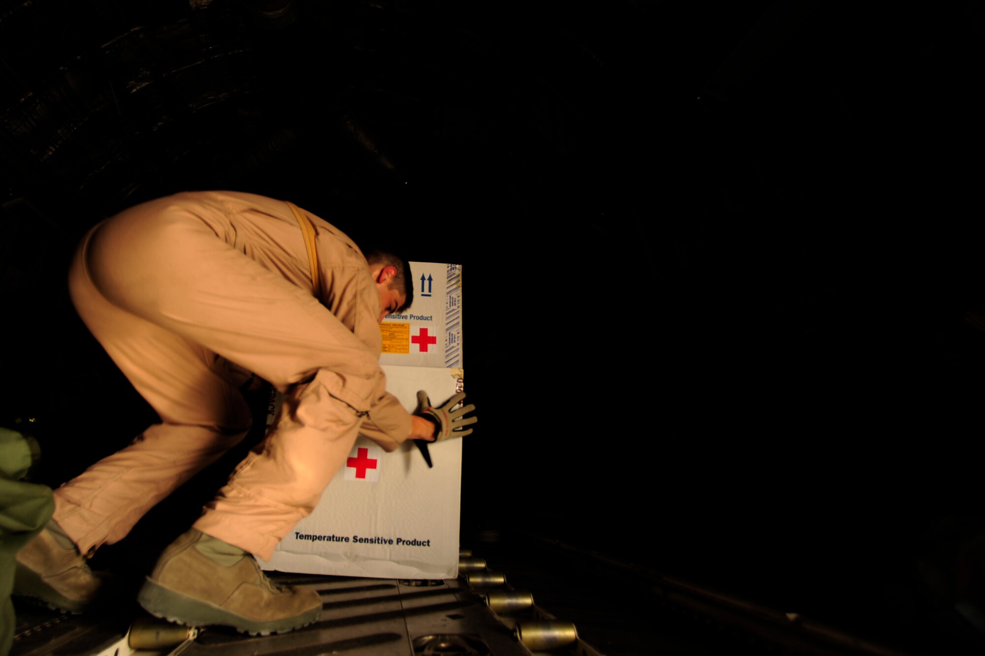 U.S. Air Force Airman First Class, Tyler Hertzog, a C-17 Globemaster III loadmaster assigned to the 816th Expeditionary Airlift Squadron, secures medical supplies for transit before takeoff to Baghdad, Iraq, while deployed to an undisclosed location in Southwest Asia on July 6, 2010. (U.S. Air Force photo by Staff Sgt. Andy M. Kin / Released)