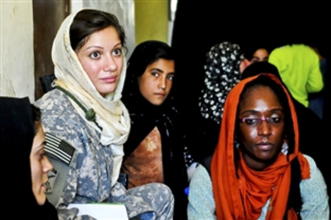 U.S. Army Sgt. Tiffany Dalagelis, left, and Marsha Michel, right, U.S. Agency for International Development field officer, meet with women participating in the Women’s Gabion Basket Weaving Project in Farah, Afghanistan, July 08, 2010. Dalagelis is a Provincial Reconstruction Team Farah civil affairs member and Female Engagement Team non-commissioned officer in charge. Michel is the engagement team coordinator for the reconstruction team.