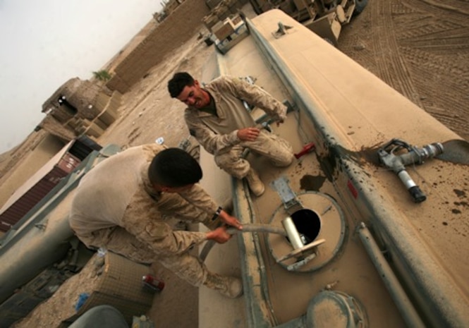 HELMAND PROVINCE, Afghanistan – Marines with Alpha Company, Combat Logistics Battalion 6, 1st Marine Logistics Group (Forward), prepare to gravity feed fuel into stationary tankers at Combat Outpost Nolay, July 13. A combat logistics patrol numbering more than three dozen vehicles arrived with fuel and communications and computer equipment after nearly two days of crawling through improvised explosive device-laden desert. The gear will enable American forces in Helmand’s volatile Sangin district to establish their own combat operations center and increase the general livability at the growing base.