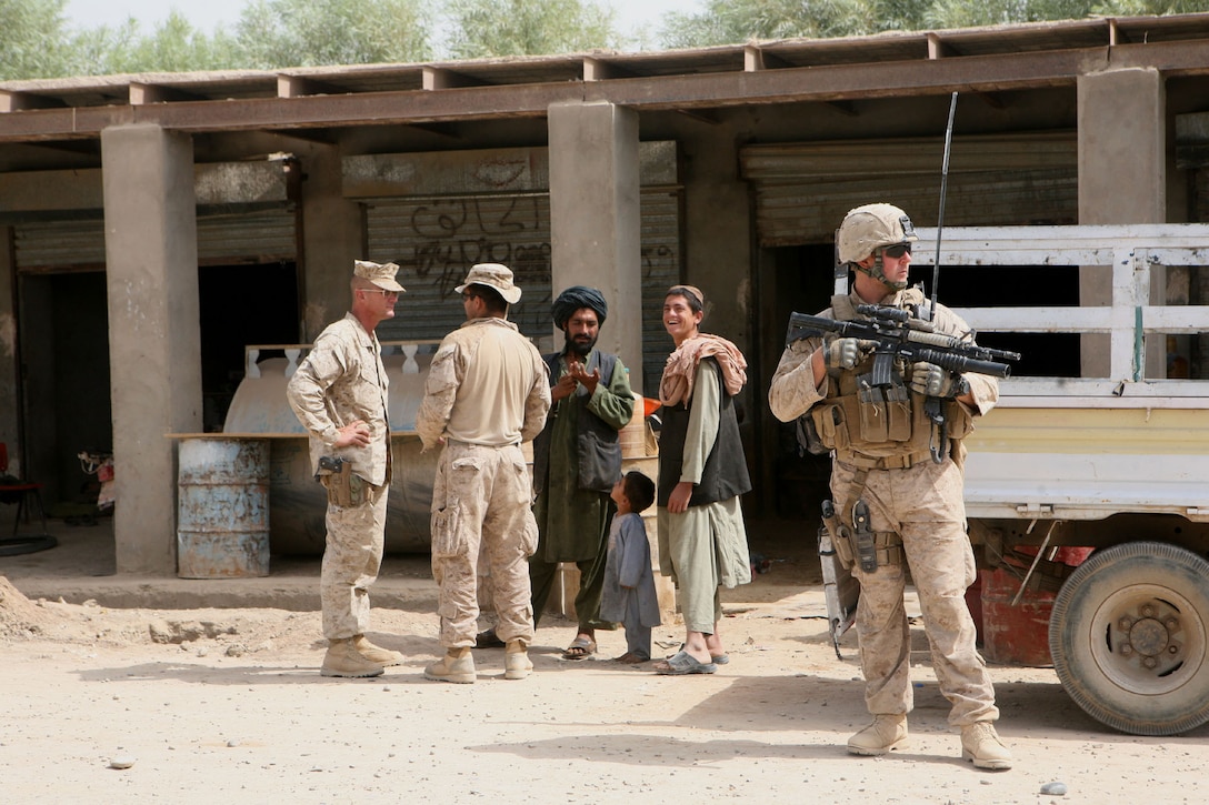 Sgt. Stephen J. Ross, a section leader with Regimental Combat Team 7 Personal Security Detachment, provides security for Col. Randall P. Newman, commanding officer of RCT-7, in Marjah, Helmand province, Afghanistan, July 14, 2010. Ross, from Baton Rouge, La., was in charge of security for an atmospheric patrol through the bazaar outside the Marjah District Center. Ross also serves as the radio operator to maintain communication between the commanding officer and the rest of his team.