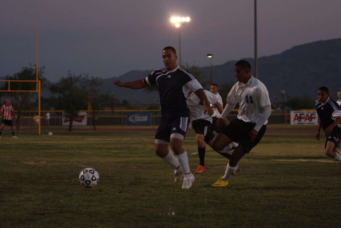 A player for the HQBN team shields the ball during the Commanding General’s Intramural Soccer League Championship game against MCCES July 14 at Felix Field.