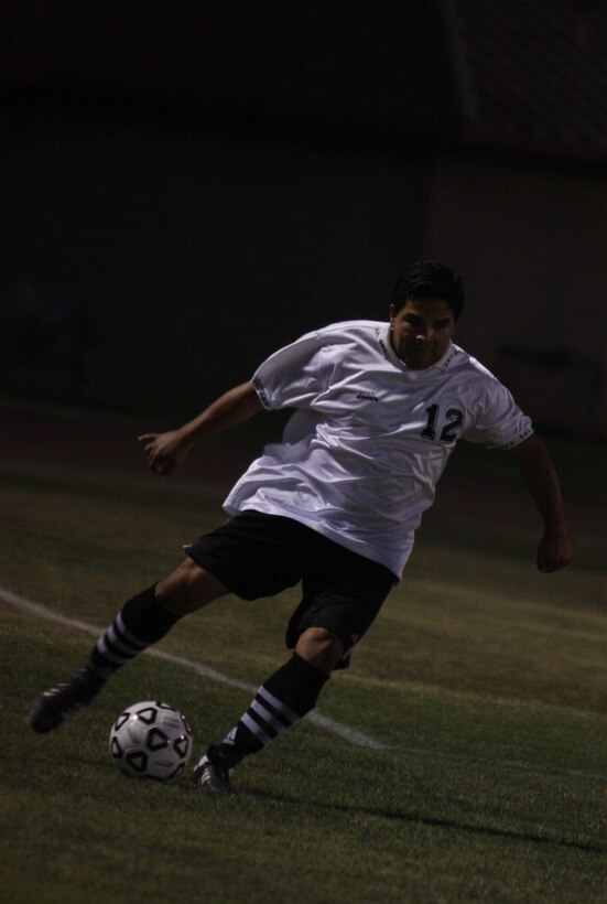 Andres Castillo, a player for the MCCES team dribbles the ball during the Commanding General’s Intramural Soccer League Championship game against HQBN July 14 at Felix Field.