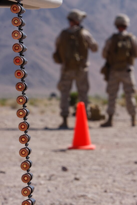 Marines load rounds into ammo belts July 14 as other Marines prepare to fire on the firing line at the Combat Center’s Range 113A. The Marines were trained in foreign weapons by the Advisor Training Group here.