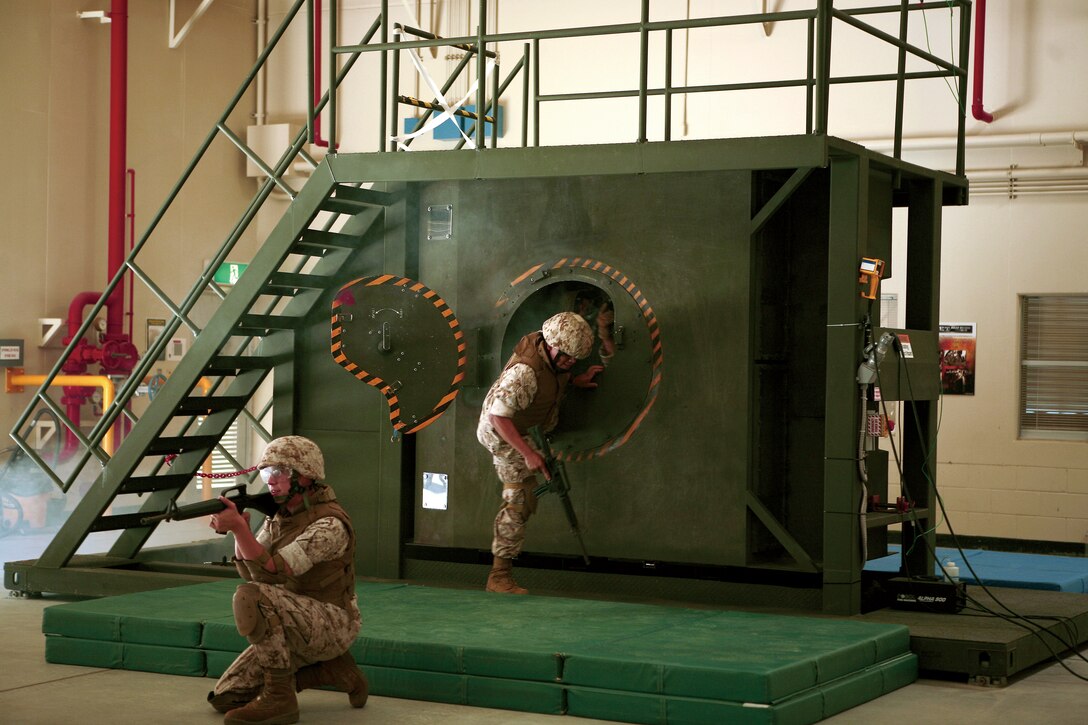 Pfc. Taylor Beckett, intelligence specialist, All Source Fusion Platoon, 3rd Intelligence Bn., III Marine Expeditionary Force, provides security for the vehicle during the Humvee Egress Assistance Trainer on Camp Hansen, July 14.