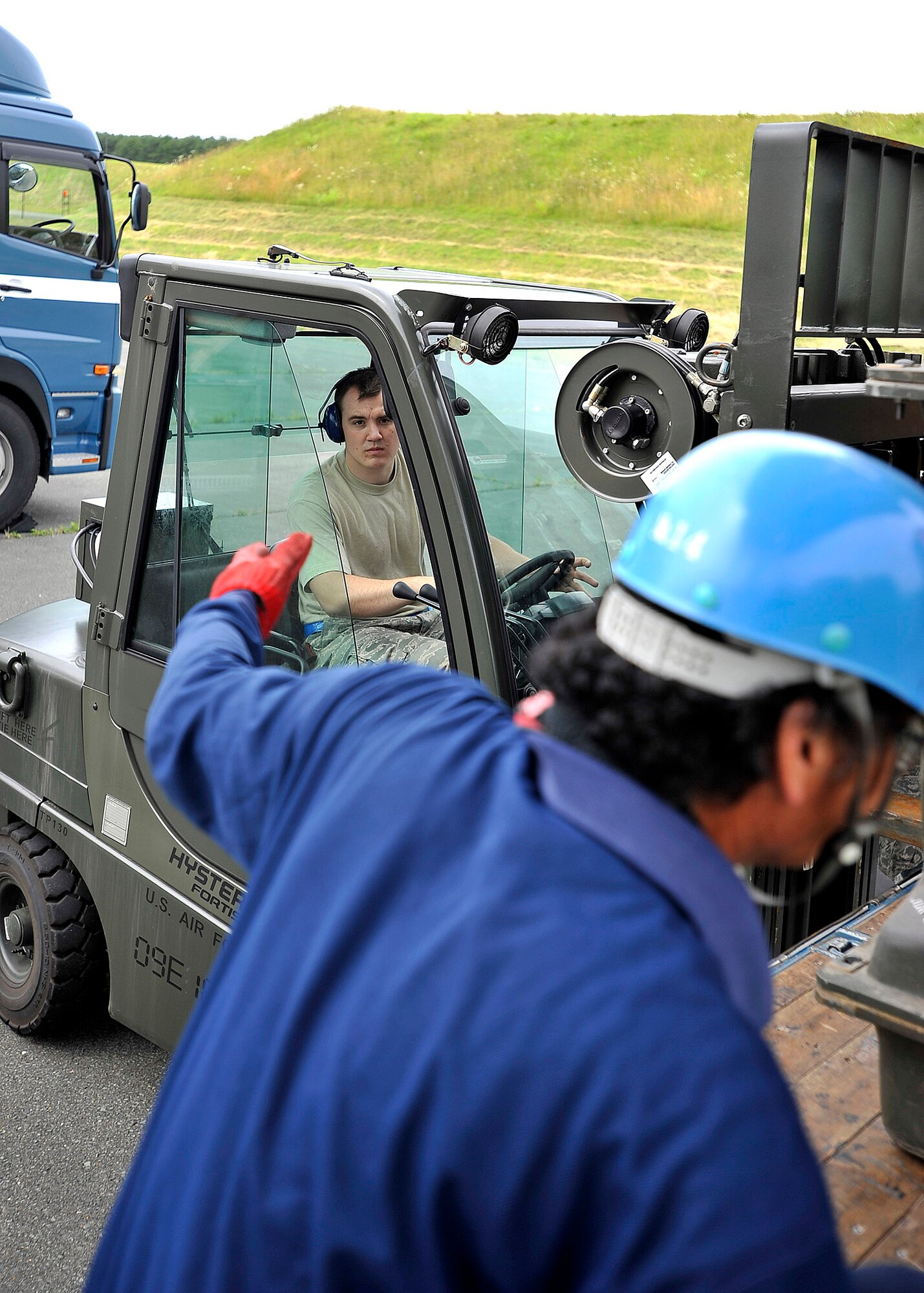 MISAWA AIR BASE, Japan -- Senior Airman Derek White, 35th Maintenance Squadron munitions systems specialist, awaits instruction from a Japanese truck driver before loading munitions July 13. The munitions flight moved more than 700 tons of munitions in an effort to dispose of unserviceable and unused equipment. (U.S. Air Force photo/Staff Sgt. Chad C. Strohmeyer)