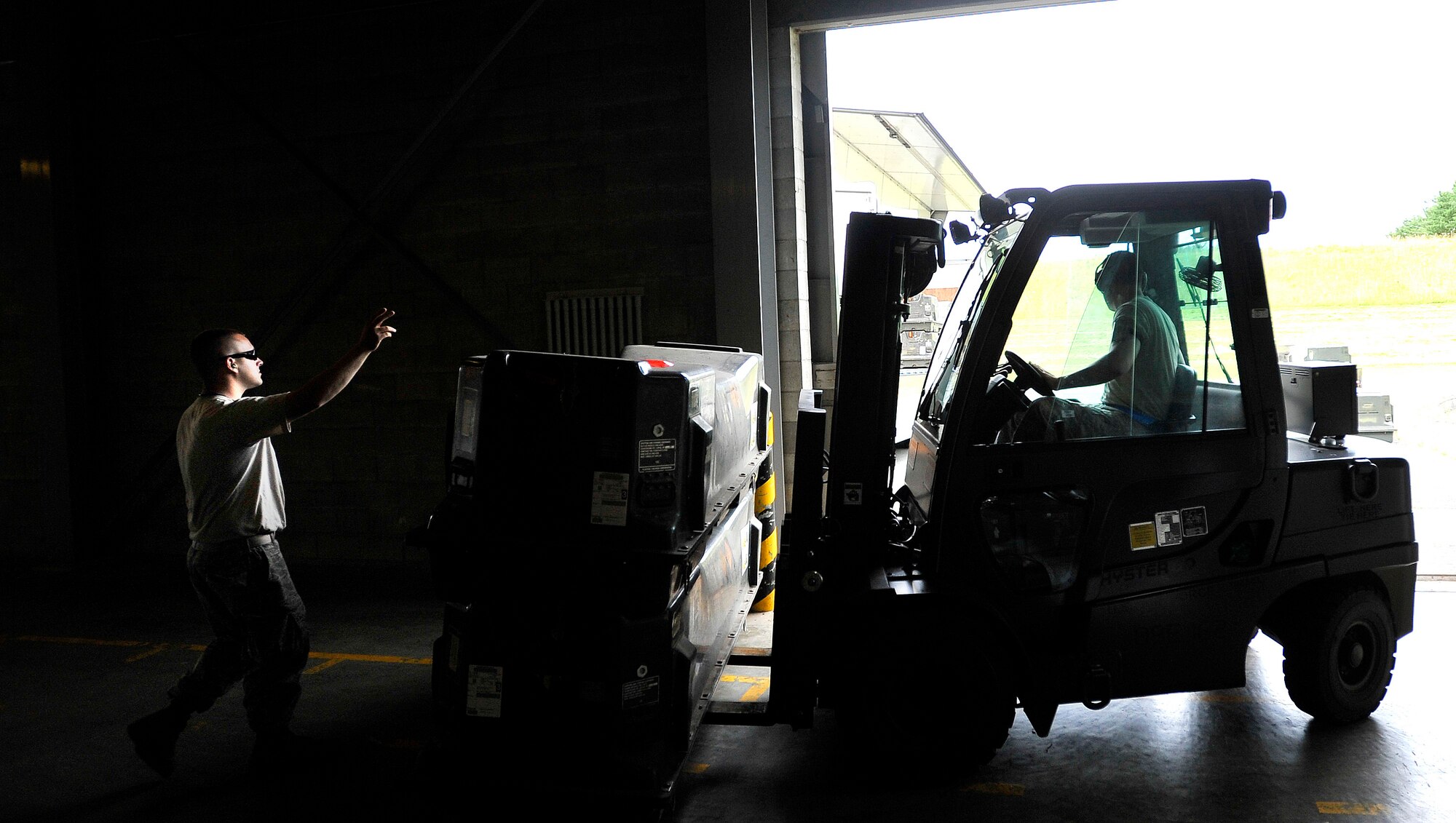 MISAWA AIR BASE, Japan ? Airman 1st Class Justin McIntire, 35th Maintenance Squadron munitions systems specialist, marshals Senior Airman Derek White, 35th Maintenance Squadron munitions systems specialist, out of a hangar while transporting munitions July 13. The munitions flight moved more than 700 tons of munitions in an effort to dispose of unserviceable and unused equipment. (U.S. Air Force photo/Staff Sgt. Chad C. Strohmeyer)