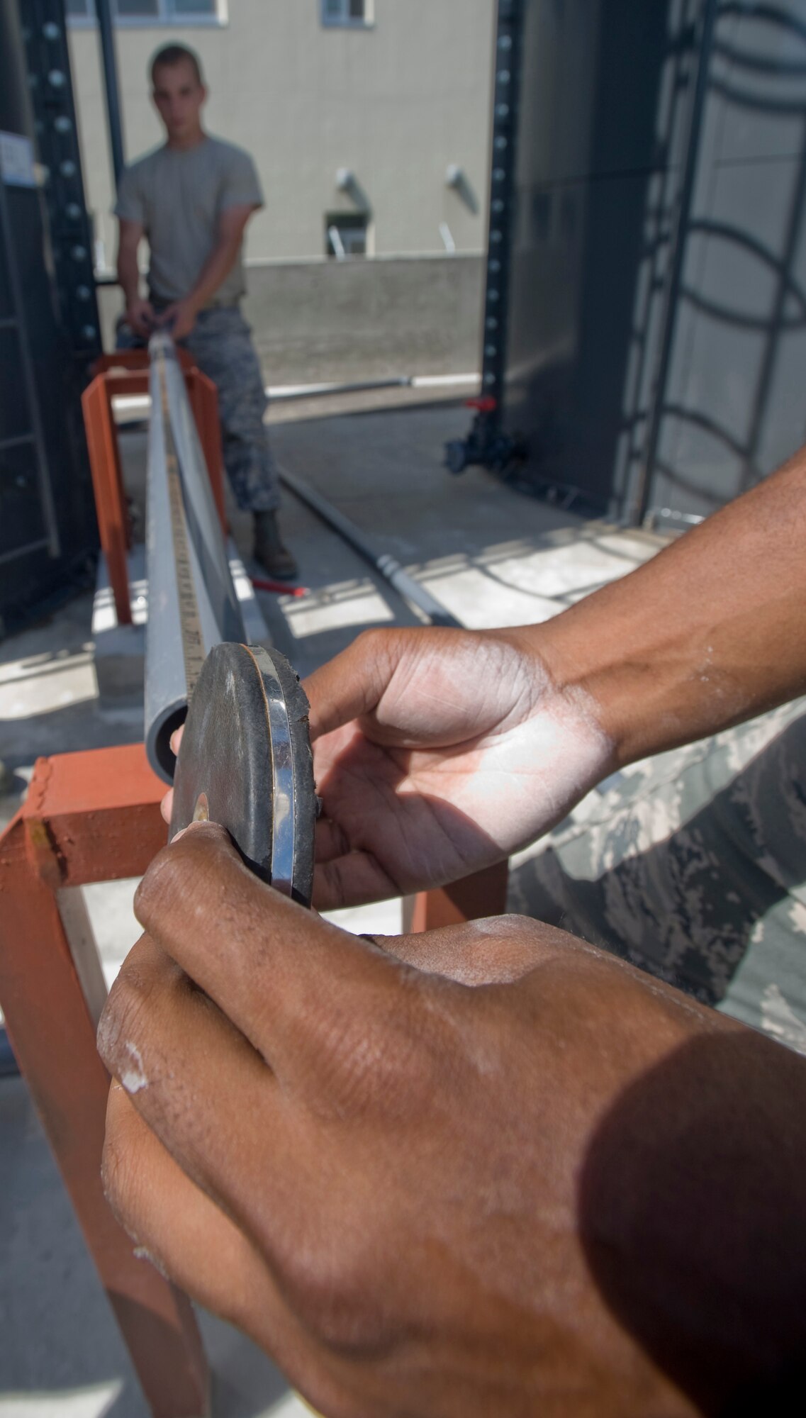 MISAWA AIR BASE, Japan -- Airman First Class Tony Rhodes and Airman First Class Jessie Hundley, 35th Civil Engineer Squadron water and fuels systems maintenance apprentices measure a piece of PVC pipe for accuracy, July 13.  The pipes are connected to new tanks of potassium acetate de-icer which will last throughout the winter season. (U.S. Air Force photo by Staff Sgt Araceli Alarcon) 