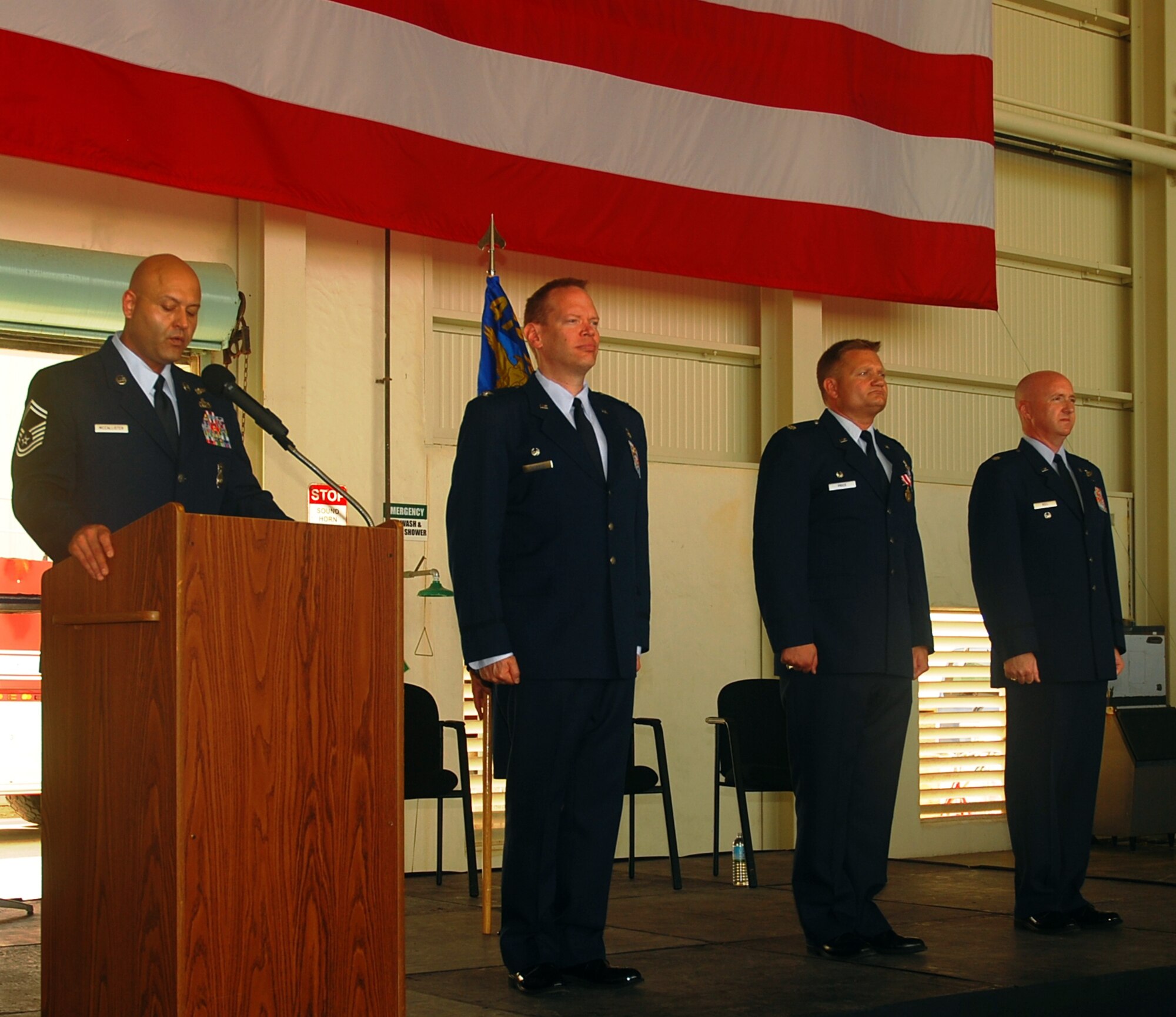 Senior Master Sgt. Benson McCallister, 429th Expeditionary Operations Squadron (EOS) Superintendent, narrates during the Change of Command ceremony while the official party, Col. WM Bruce Danskine, 474th Air Expeditionary Group Commander, Lt. Col. Mike Price, outgoing 429th EOS Commander and Lt. Col. Brian Bell, incoming 429th EOS Commander, stand fast before the changing of the guidon.  (Courtesy photo)