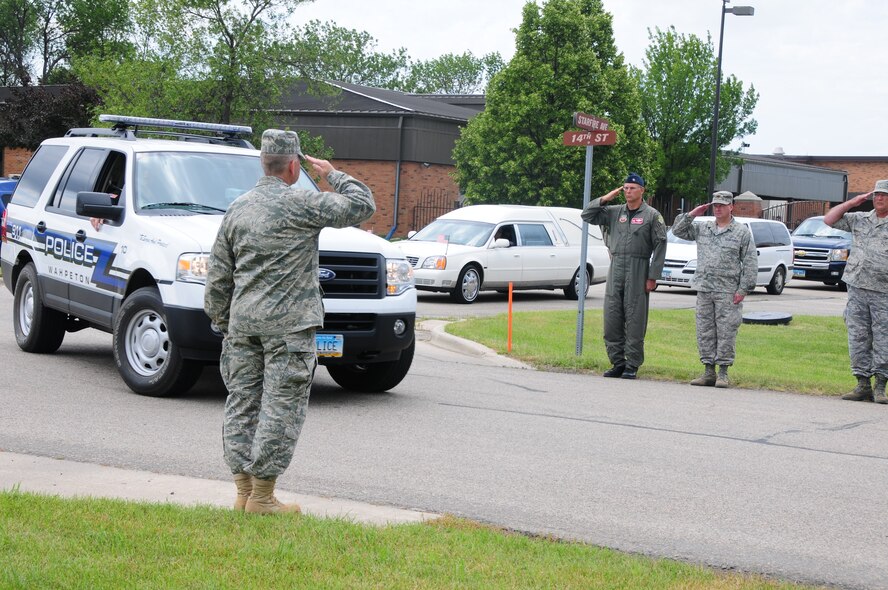 Members of the North Dakota Air National Guard salute as the remains of U.S. Army Spc. Keenan Cooper pass by in a hearse July 14, Fargo, N.D. Cooper's remains are being transferred from Fargo to his hometown of Wahpeton, N.D., for the funeral on Friday, July 16. Motorcycle riders of the North Dakota Patriot Guard and North Dakota Legion Riders are led by the North Dakota Highway Patrol and other local law enforcement, as they are escorting Cooper's remains from Fargo to his hometown of Wahpeton, N.D.COMMA where his funeral will take place on Friday, July 16.