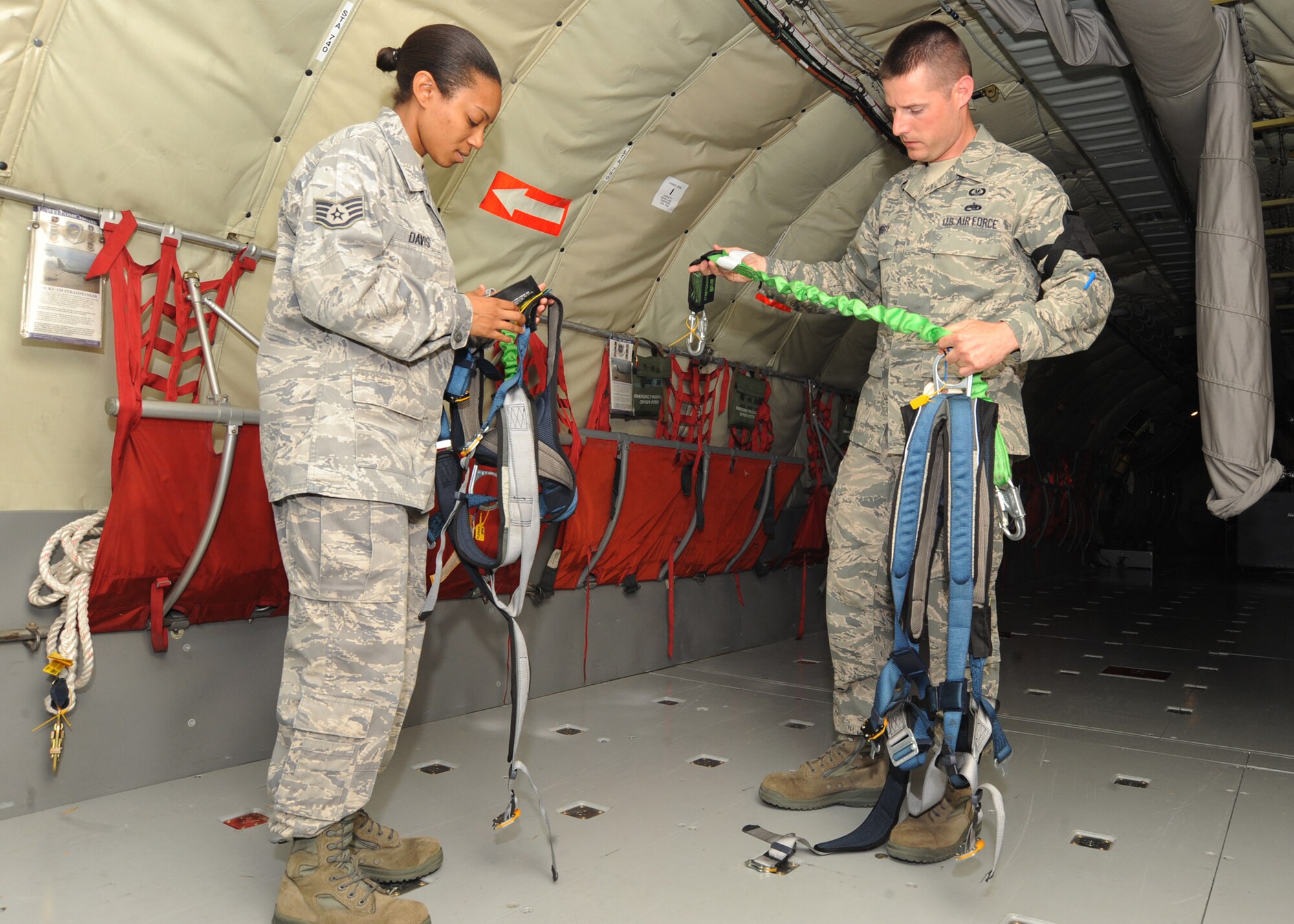 Staff Sgt. Latrica Davis and Staff Sgt. Daniel Sperry, 22nd Air Refueling Wing ground safety technicians, look at safety chords for damaged areas aboard a KC-135 Stratotanker June 16, 2010, McConnell Air Force Base, Kan.  The ground safety program assists in performing operational risk assessments at operational and occupational levels to include industrial, contractual, sports, recreation and traffic areas.  Ground safety develops and maintains current Air Force Occupational Safety and Health standards, performs oversight, conducts major command ground safety program evaluations, performs mishap final evaluations and provides lessons-learned analysis to base units.  (U.S. Air Force photo/ Senior Airman Maria Ruiz