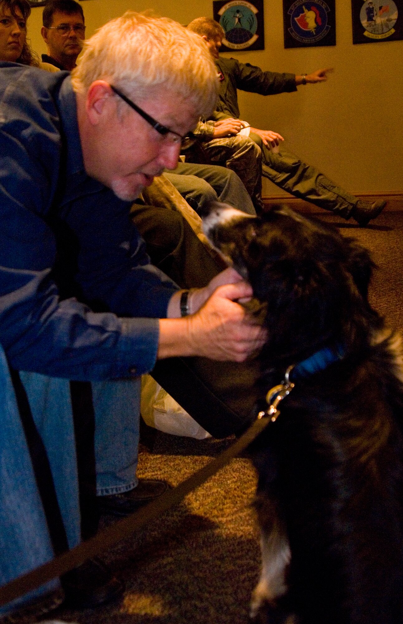 Doug Watson, McConnell neighboring landowner, pets Vasi, a border collie for the Bird Aircraft Strike Hazard program July 9, 2010, McConnell Air Force Base, Kan.  Using the dog to help relocate birds from property surrounding McConnell’s flight line is one of the most cost-effective methods for the BASH program, and has helped reduce the number of bird strikes by one-third.  (U.S. Air Force photo/Senior Airman Abigail Klein)