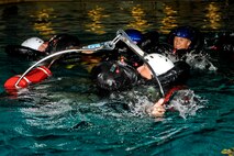 MINOT, N.D. -- Aircrew members from the 69th and 23rd Bomb Squadrons practice water survival techniques during an aircrew water training course at the Minot State University pool here July 13. The refresher course helped sharpen aircrew member’s skills in order for them to be properly prepared for real world survival scenarios. The course was lead by Senior Airman Brett Steinbrink of the 5th Operations Support Squadron. Airman Steinbrink is a survive, evade, resist and escape specialist. (U.S. Air Force photo by Airman 1st Class Aaron-Forest Wainwright)