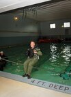 MINOT, N.D. -- Capt. Steve Koltonski, 69th Bomb Squadron navigator, jumps into the water during an aircrew water training course at the Minot State University pool here July 13. The refresher course helped sharpen aircrew member’s skills in order for them to be properly prepared for real world survival scenarios. The course was lead by Senior Airman Brett Steinbrink of the 5th Operations Support Squadron. Airman Steinbrink is a survive, evade, resist and escape specialist. (U.S. Air Force photo by Airman 1st Class Aaron-Forest Wainwright)