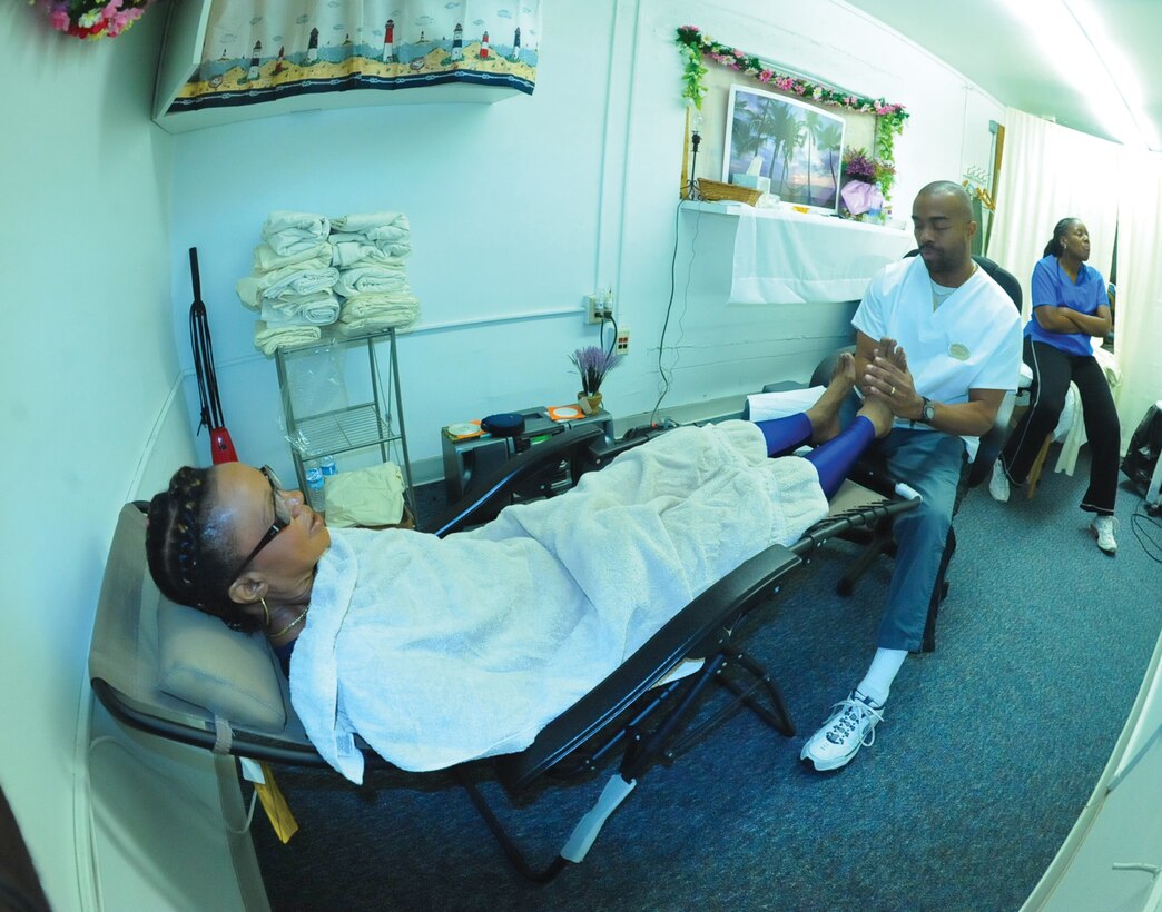 JOINT BASE ANDREWS, Md. -- Francois Duncan, military dependent, rests comfortably in a lafuma chair as Cory Scoggins, massage team manager, performs reflexology techniques on her feet inside the Therapy Room at the West Fitness Center Wednesday. The primary services offered at the fitness center also include massage therapy. Mobile massages are also available. The Therapy Room is open Monday through Thursday 8 a.m. to 5 p.m. and Friday 8 a.m. to 3 p.m. For an appointment, call 301-467-5595.  (U.S. Air Force photo by Bobby Jones)