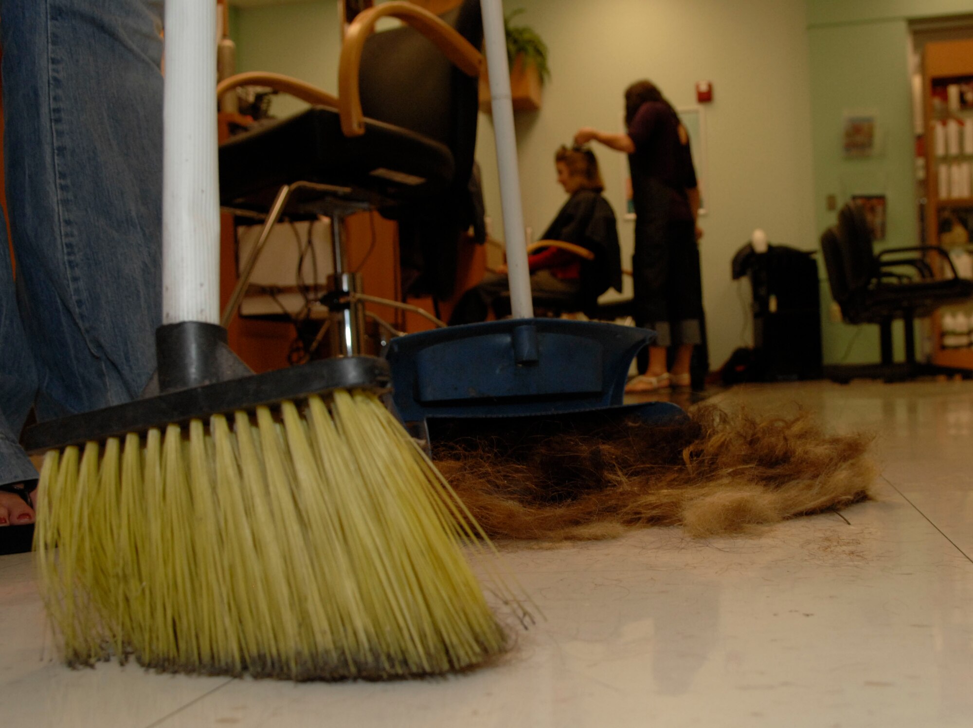 SCOTT AIR FORCE BASE, Ill. -- A stylist at the Base Exchange beauty salon collects hair clippings to be donated to an organization that makes booms to soak up oil.(Courtesy Photo)