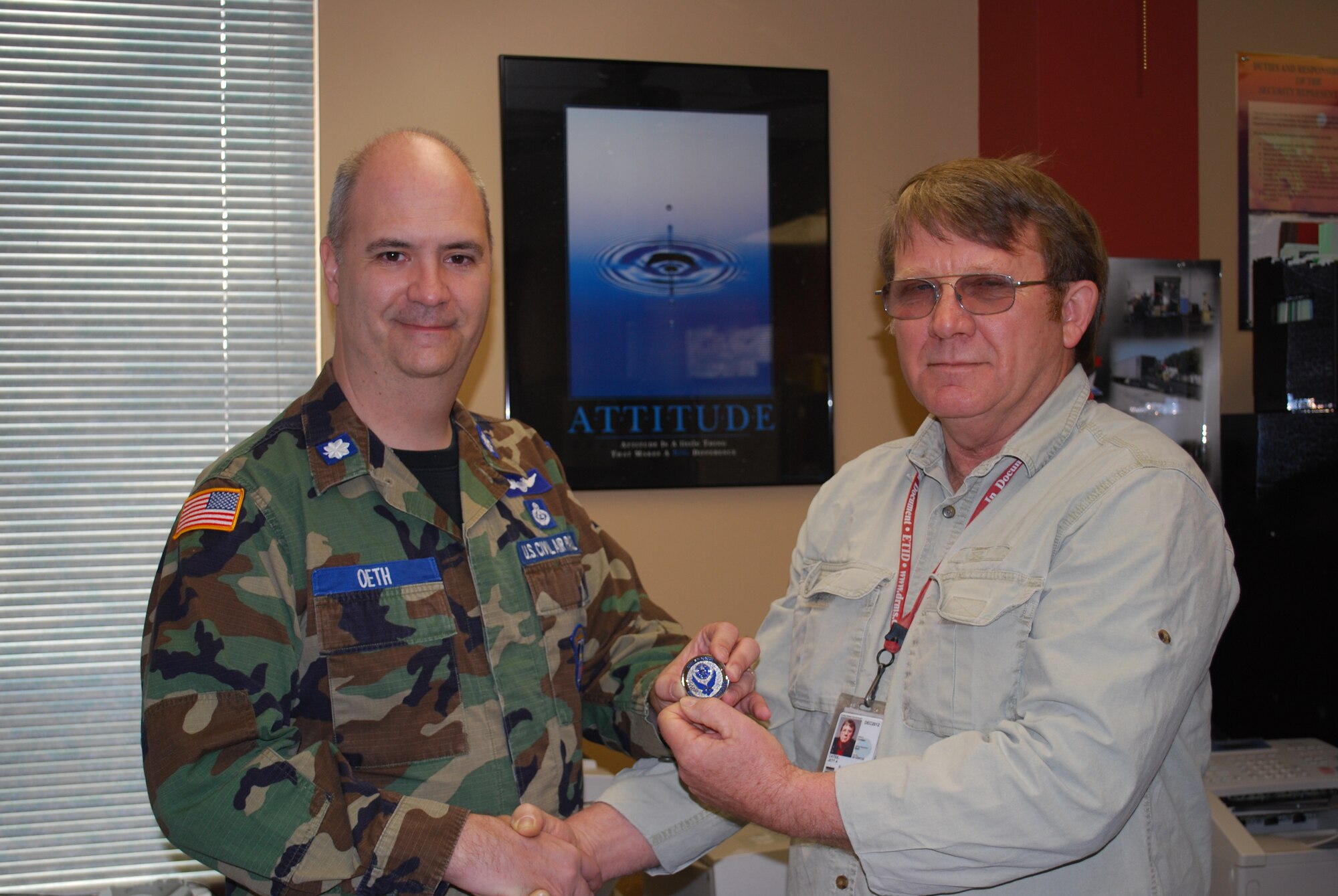 SCOTT AIR FORCE BASE, Ill. -- Lt. Col. Rick Oeth, Civil Air Patrol Illinois Wing vice commander, presents a commemorative communications coin to Jett Cates, Defense Reutilization and Marketing Office disposal service representative, for his dedication to the CAP program. (Courtesy Photo)