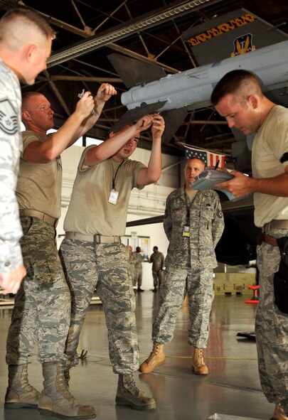 100709-F-4406D-053 SHAW AIR FORCE BASE, S.C.--    Airman 1st Class Allen Hayes, Airman 1st Class James Helmick, and Staff Sgt. Samuel Arpy from the 79th Aircraft Maintenance Unit "Tigers" finish loading the AIM-9M missile to the F-16 for the Weapon Load Crew Competition in Hanger 611, July 9, 2010. In the second Weapons Load Crew of the Quarter competition this year, two crews competed to become eligible for the Load Crew of the Year and to showcase the Tech. Sgt. Charles D. Lockwood Memorial trophy. (U.S. Air Force photo/ Airman 1st Class Tabatha L. Duarte)