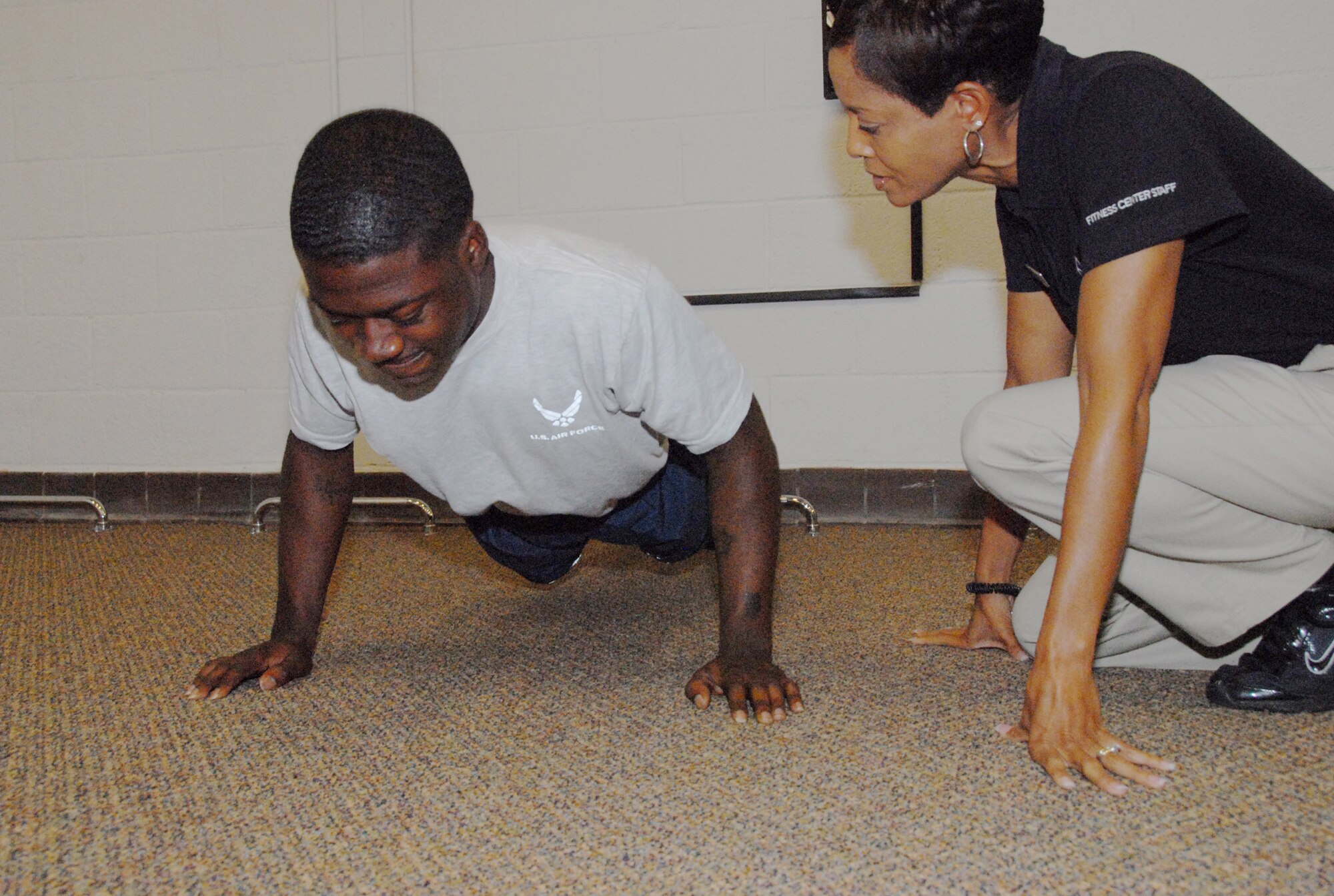 Airman 1st Class, Arthur Burney does pushups under the watchful eyes of Felicia Gomez-Stewart, Firness Assessment Cell technician. U. S. Air Force photo by Wayne Crenshaw