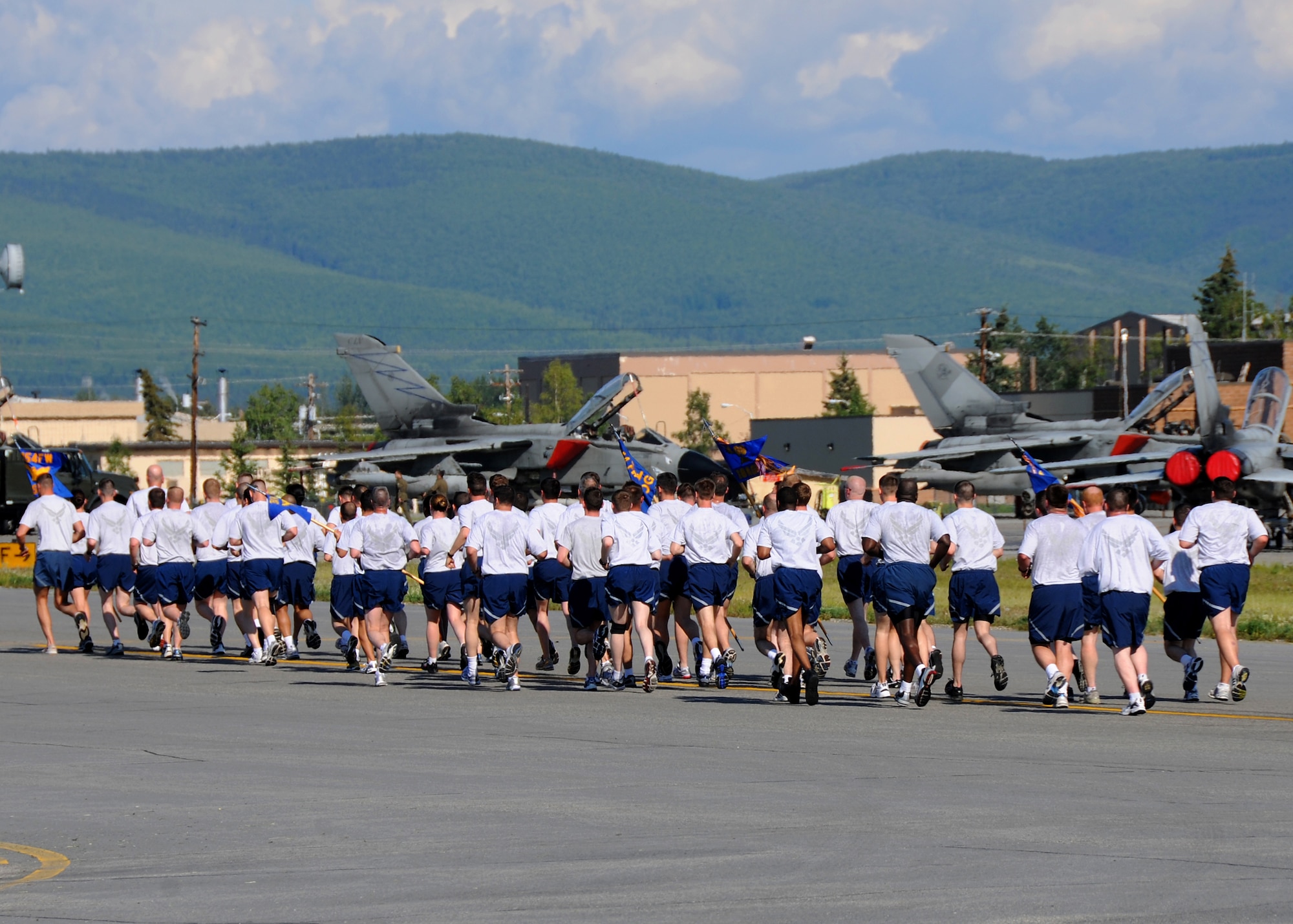 Airmen of the 354th Fighter Wing run on the flightline during a wing run on July 2, 2010 at Eielson Air Force Base, Alaska.  Due to the harsh winters in Alaska, most Eielson Airmen are only able to perform physical fitness outside from May through August.  (U.S. Air Force photo/Staff Sgt. Tia Wilson)