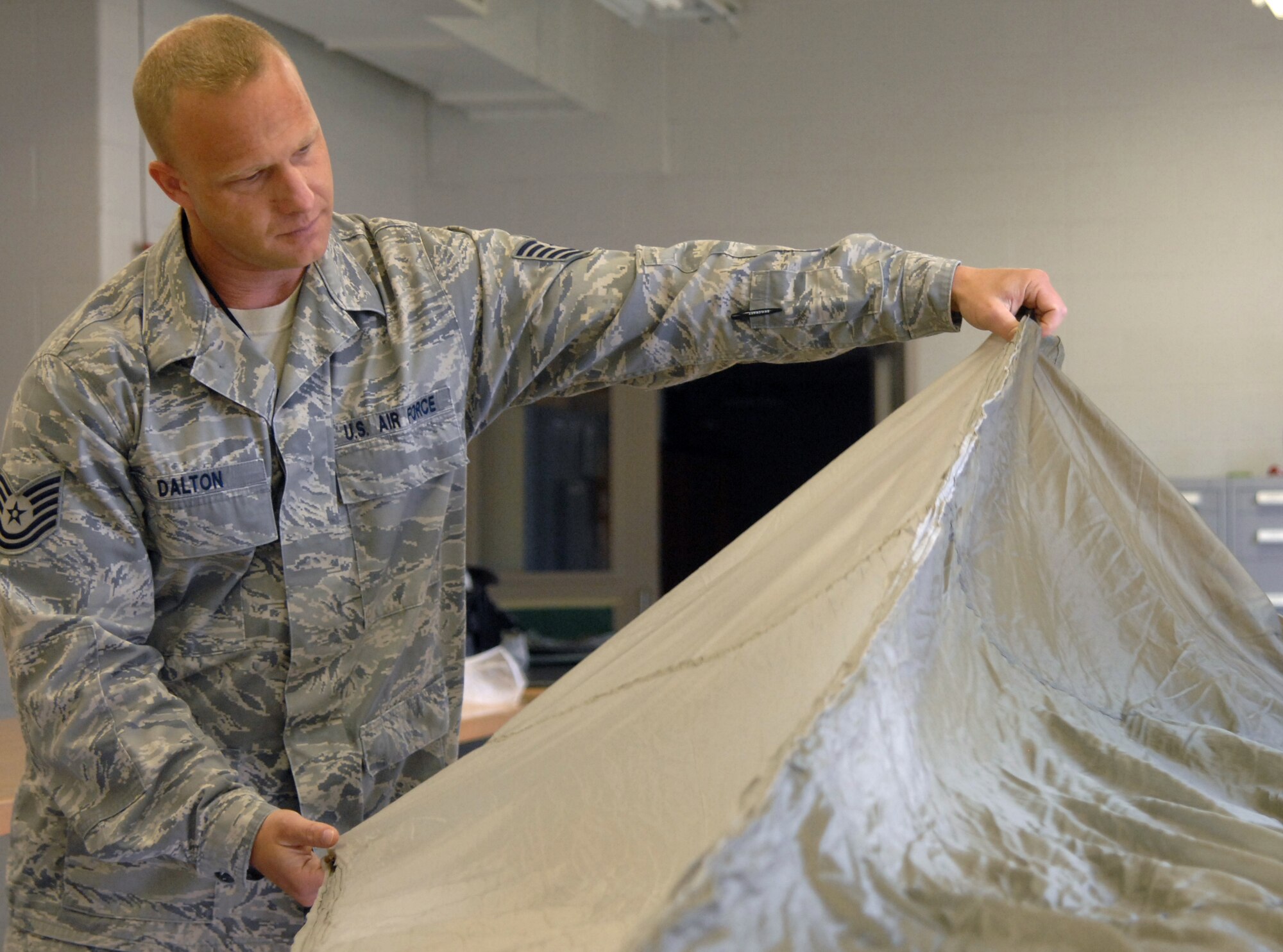 WHITEMAN AIR FORCE BASE, Mo., -- Tech Sgt. Clinton Dalton 509th Operations Group NCO in charge of quality assurance, inspects the BA-22 parachute canopy. The room must maintain a certain temperature and humidity to prevent moisture from hindering chute deployment. 
(U.S. Air Force photo/Staff Sgt. Jason Huddleston) (Released)

