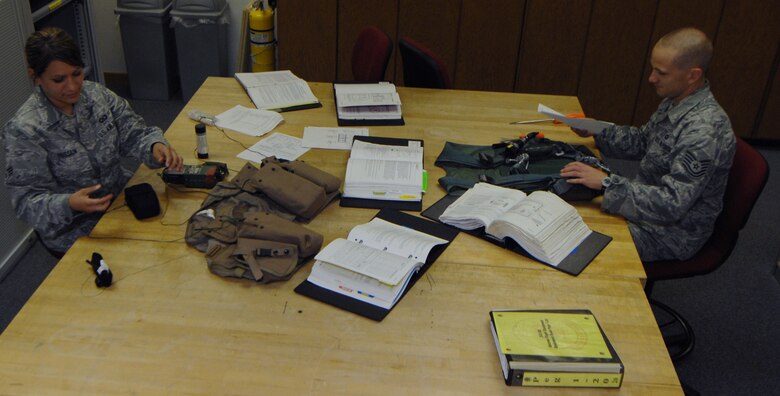 WHITEMAN AIR FORCE BASE, Mo., -- Senior Airman Ashley Hussian, 393rd Aircrew Flight Equipment technician and Tech. Sgt. Michael Cole, 393rd AFE NCO in charge, use technical orders to inspect aircraft safety equipment. The 393rd Aircrew Flight Equipment shop specializes in safety for the B-2 aircraft.
(U.S. Air Force photo/Staff Sgt. Jason Huddleston) (Released)

