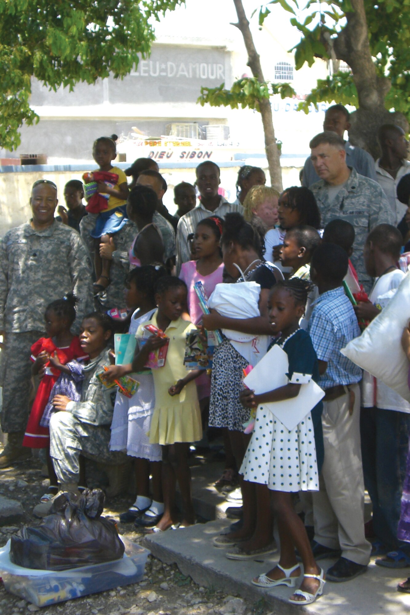HAITI - Lt. Col. Kevin K. Callies, 114th Fighter Wing comptroller, and his staff are surrounded by many of the local children they are deployed to help in Haiti when they visited an orphanage there on May 16.  The children surrounded the military members and began to sing Hallelujah upon seeing the task force members arrive. (Photographer unknown - released)