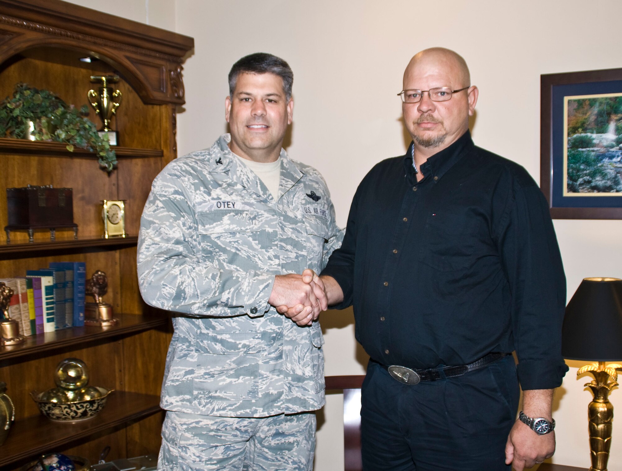 Col. Greg Otey, 19th Airlift Wing commander, presents a coin July 13 to Terry Thomas, 19th Mission Support Group resource advisor, for his selection as the Combat Airlifter of the Week. Mr. Thomas is the 2010 Air Show resource advisor responsible for the execution and management of $250,000 spread over seven accounts. (U.S. Air Force photo by Staff Sgt. Nestor Cruz)