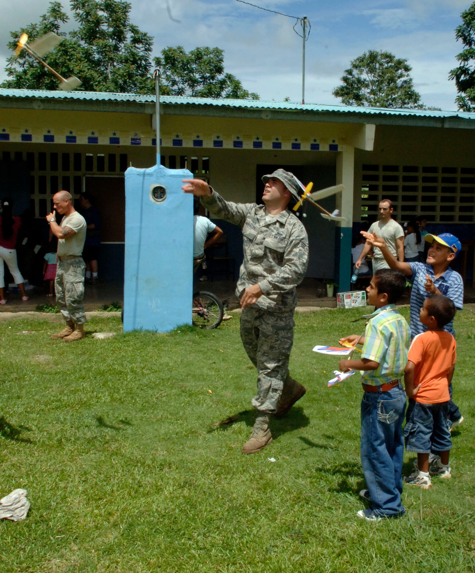 Senior Airman Cesar Morales, 820th Expeditionary RED HORSE Squadron, launches rubber band airplanes with students at the Sansonsito School July 12. (U.S. Air Force photo/Tech. Sgt. Eric Petosky)