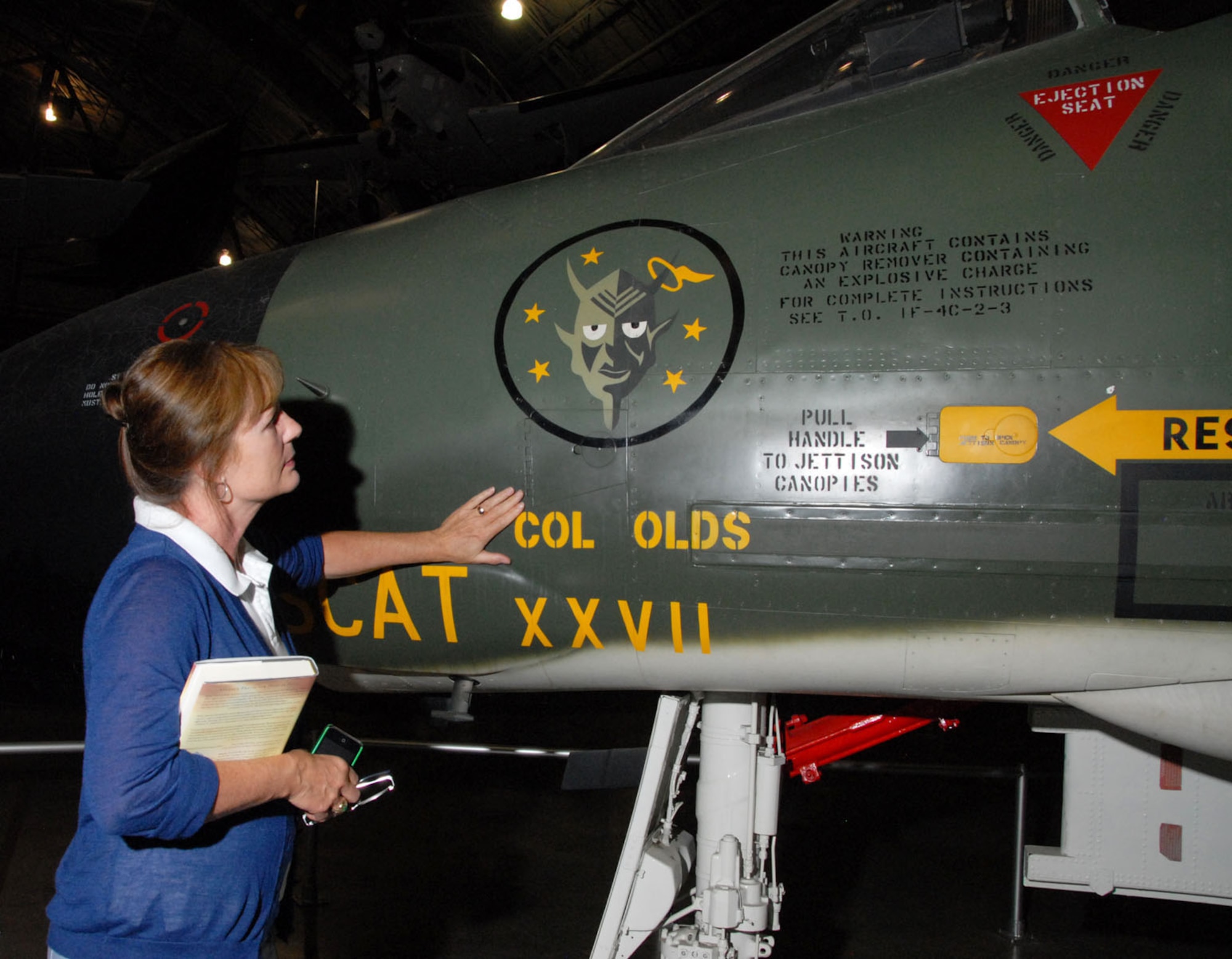DAYTON, Ohio -- Christina Olds, daughter of the late triple ace and Air Force Cross recipient Brig. Gen. Robin Olds, touches her father's F-4C Phantom II at the National Museum of the U.S. Air Force. (U.S. Air Force Photo)