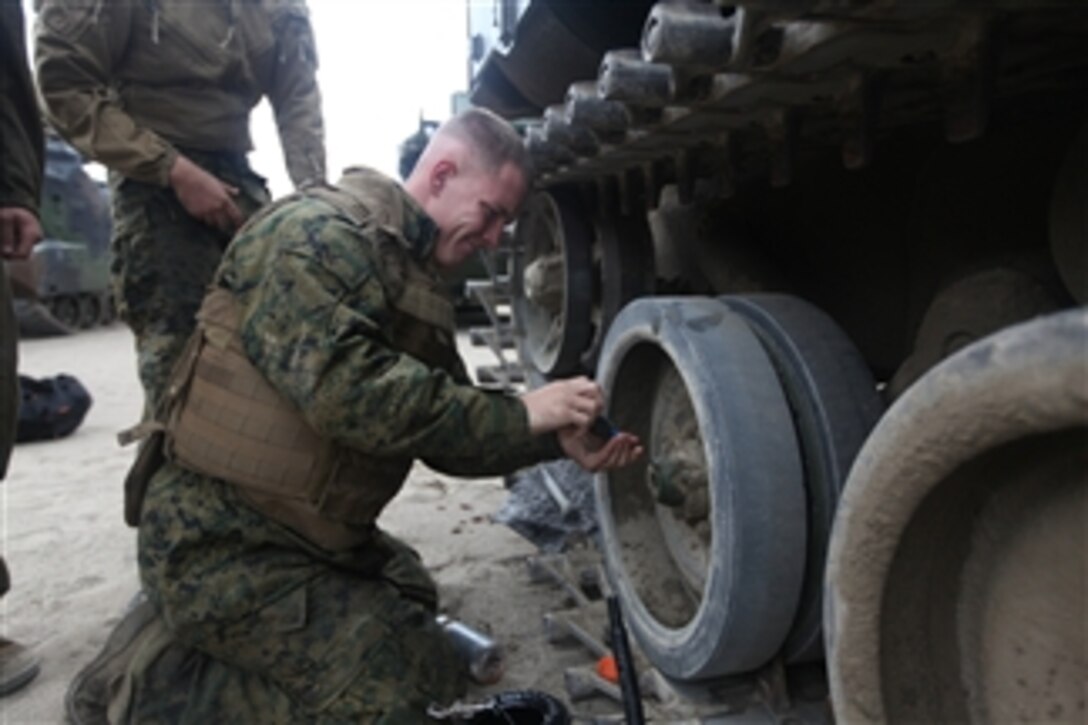 A U.S. Marine with 4th Platoon, Charlie Company, 3rd Assault Amphibian Battalion, 1st Marine Division fixes the track of his amphibious assault vehicle on a beach in Ancon, Peru, on July 7, 2010.  The Marines are embarked aboard the transport dock ship USS New Orleans (LPD 18) in support of Partnership of the Americas/Southern Exchange, a combined amphibious exercise with maritime forces from Argentina, Mexico, Peru, Brazil, Uruguay and Colombia.  