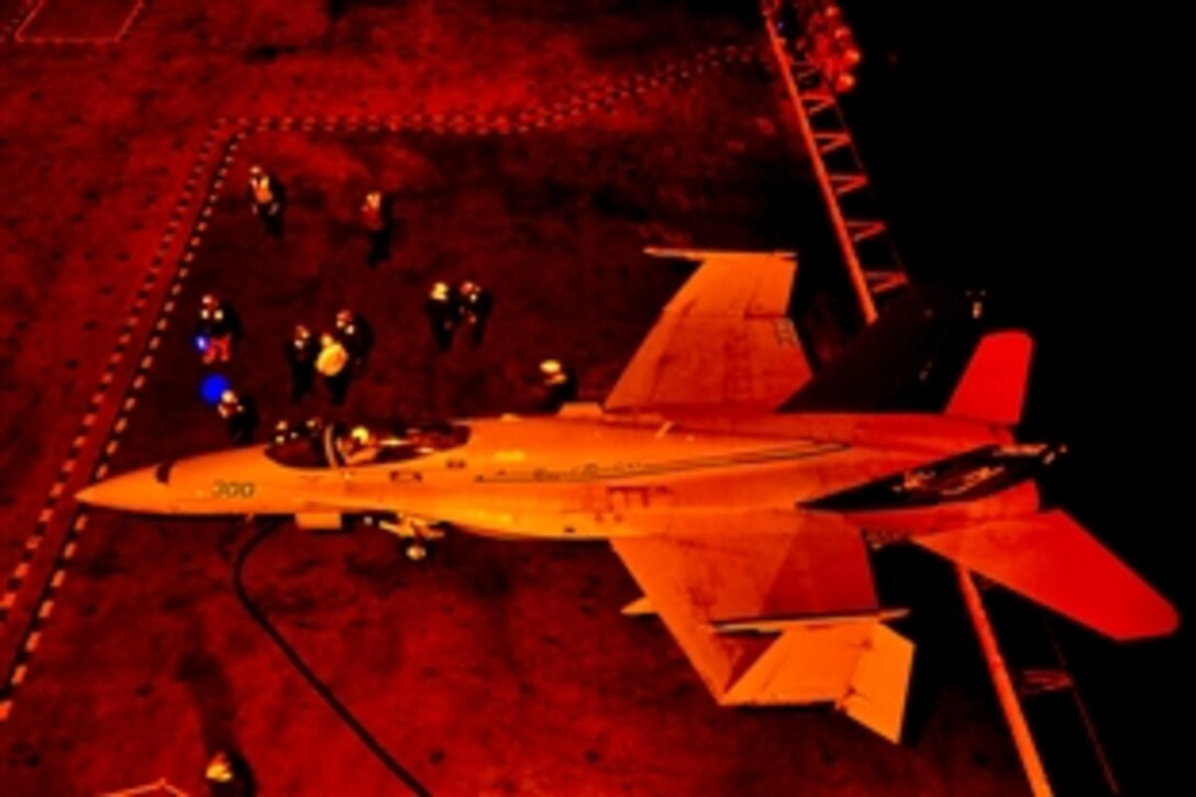 U.S. Navy sailors refuel an F/A-18 Super Hornet aircraft during night-flight operations on the USS Carl Vinson in the Pacific Ocean, July 12, 2010. 