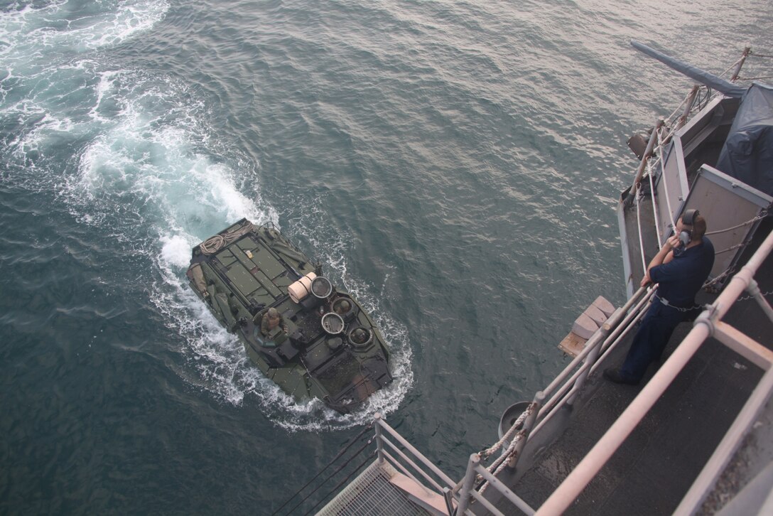A Sailor aboard the USS Iwo Jima watches as Marines embark an Amphibious Assault Vehicle into the ship’s well deck, July 15, 2010. The Marines are from Company A, 2nd Assault Amphibian Battalion and are participating in a four-month deployment to Central and Latin America in support of Continuing Promise 2010.