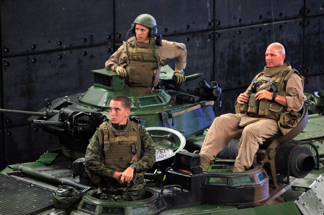 U.S. Marines from Alpha Company, 2nd Amphibious Assault Vehicles, attached to Special-Purpose Marine Air-Ground Task Force Continuing Promise 2010, stand by after entering the well deck of the USS Iwo Jima, July 15. Marines and Sailors are deploying in support of Operation Continuing Promise 2010 to provide humanitarian assistance and disaster relief to Caribbean, Central and South America.