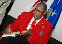 Retired Chief Master Sgt. Walter Richardson signs a copy of his autobiography for an awaiting Airman inside the Duke Field base theater July 10.  An original member of the famed World War II-era Tuskegee Airmen, the 30-year veteran later spoke to a mass audience of 919th Special Operations Wing reservists about his role as one of the first African-American Airmen tasked to begin integrating the fledgling U.S. Air Force.   (U.S. Air Force photo/Tech. Sgt. Cheryl Foster)