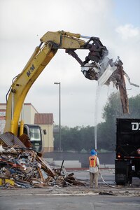 Contractors remove debris during the demolition of the old BX July 15 to make way for a new parking lot in its place. Plans are in place to create temporary routes to alleviate congestion in around the new BX until the parking lot can be completed. (U.S. Air Force photo/Steve Thurow)