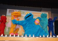 Cookie Monster and his friends perform on stage during the USO sponsored Sesame Street Experience July 8 at the Bob Hope Performing Arts Center. (U.S. Air Force photo/Alan Boedeker)
