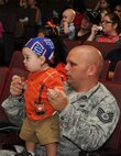 Tech. Sgt. Nathan Rohdert, 343rd Training Squadron, and his son Cage watch the Sesame Street/USO Experience for Military Families July 8 at the Bob Hope Performing Arts Center. (U.S. Air Force photo/Alan Boedeker)