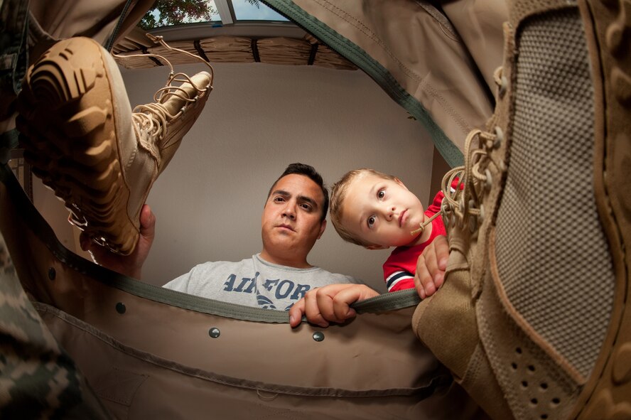 Master Sgt. Rudy Gamez and his son, Tomas, 4 are in their home in San Antonio, Texas, on July 13, 2010.   Helping his father pack helps him become a part of the deployment process and understand the time apart from his father. Later this year Sgt. Gamez and his wife Tech. Sgt. Christina Gamez will both be deployed and blog about their experiences.   (U.S. Air Force photo/Lance Cheung)
