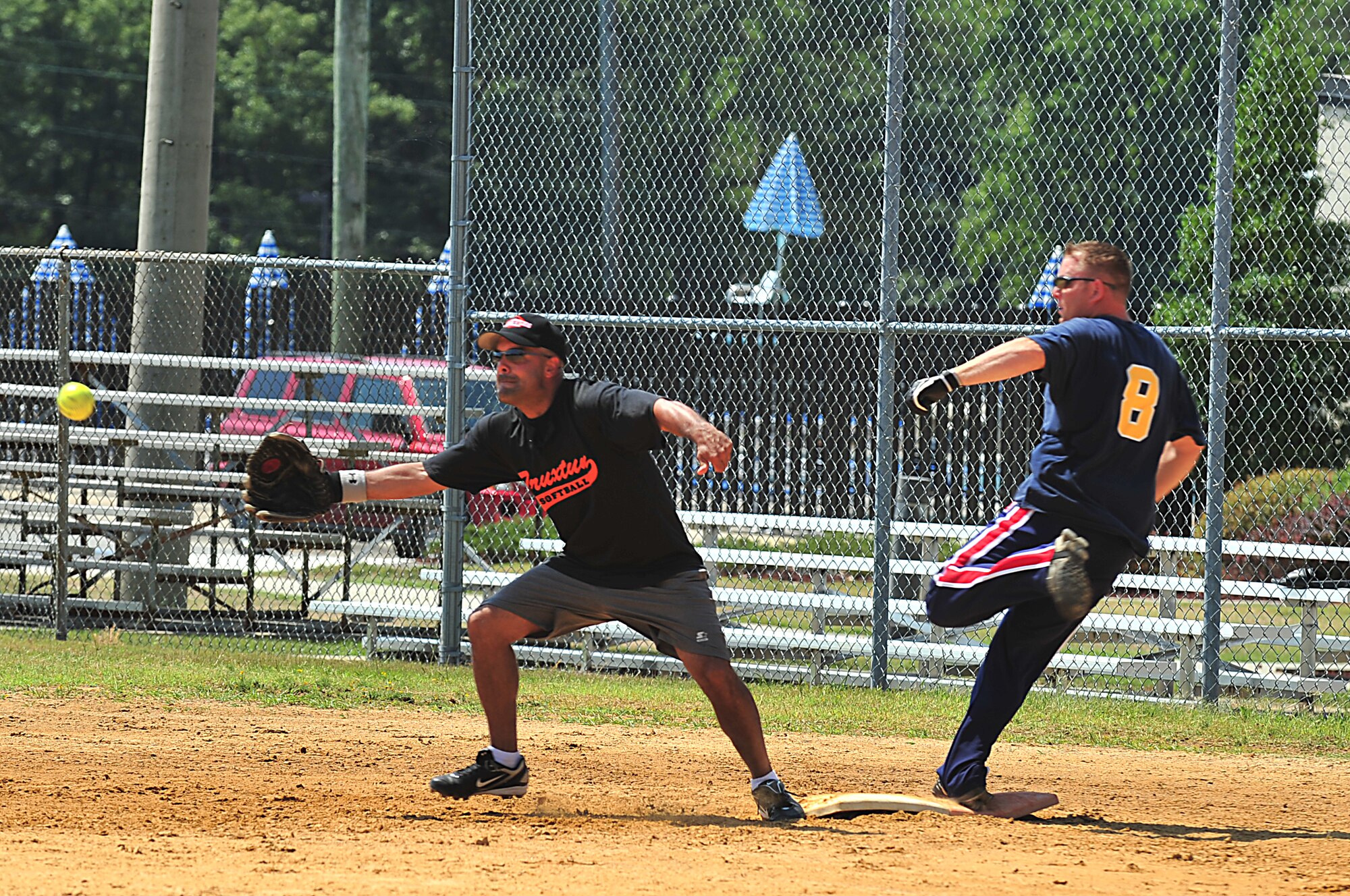 SEYMOUR JOHNSON AIR FORCE BASE, N.C. -- Jesus Pavon stretches for the ball as Chris Vanderpoel reaches first base during the Eagles Grand Slam Jamboree Softball Tournament championship game here July 11, 2010. Airmen and Sailors competed against one another in the championship game. The Misfits from Seymour Johnson, having home field advantage, won 15-14. Pavon, Truxtun first baseman, hails from Miami. Vanderpoel, The Misfits right center fielder, is from Dundee, N.Y. (U.S. Air Force photo/Senior Airman Rae Perry)