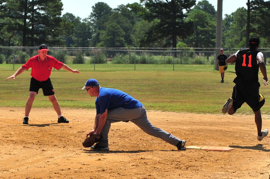 SEYMOUR JOHNSON AIR FORCE BASE, N.C. -- A referee signals Emanuel Lee safe as he runs through first base during the Eagles Grand-Slam Jamboree Softball Tournament championship game here July 11, 2010. The tournament included a home run derby and round robin tournament with a championship game. Lee is a Sailor stationed on the USS Truxtun out of Norfolk, Va., and hails from Crisfield, Md. (U.S. Air Force photo/Senior Airman Rae Perry)