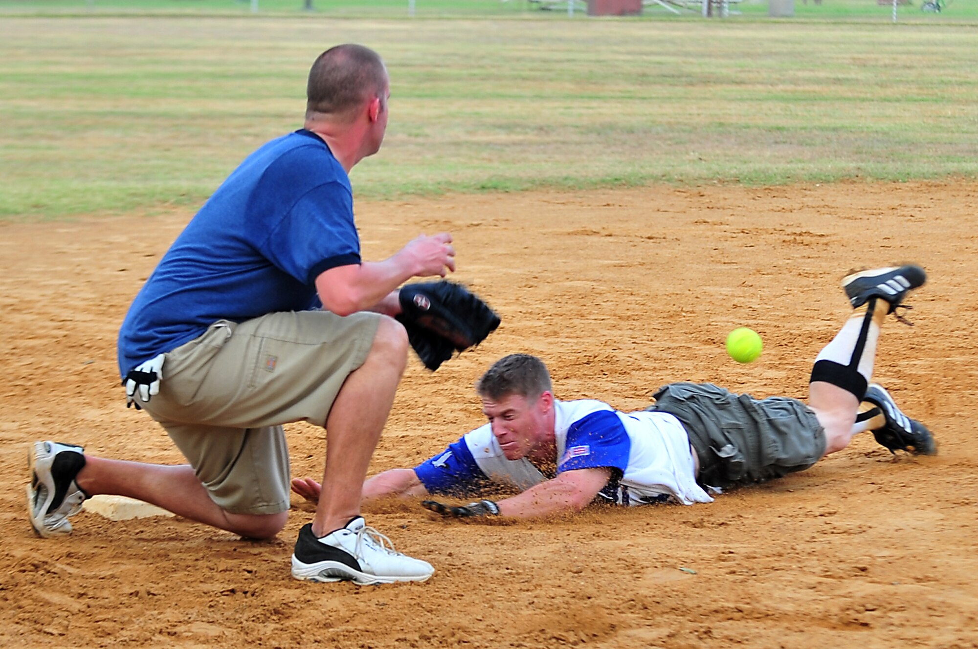 SEYMOUR JOHNSON AIR FORCE BASE, N.C. -- Zachary Nass prepares to make a tag as Curtis Dougherty slides into third base during an Eagles Grand Slam Jamboree softball game here July 10, 2010. Each game was seven innings unless the score was tied, in which case teams played extra innings. Nass, Misfits third baseman, hails from Seattle and Dougherty, Team Ops first baseman, is from Downinton, Pa. (U.S. Air Force photo/Senior Airman Rae Perry)