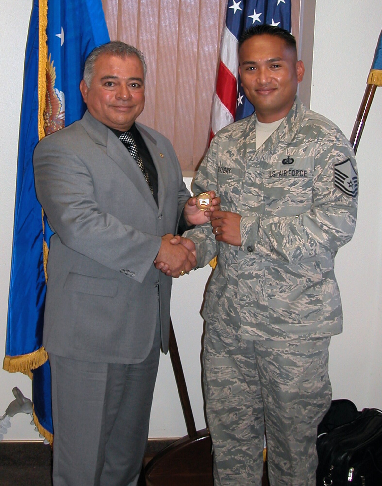Master Sgt. Jonathan Gaygay accepts a coin from Mr. Rocky J. Chavez, Undersecretary of Veterans Affairs for the state of California. Sergeant Gaygay and seven other members of the Blue Eagles Total Force Honor Guard were awarded with coins and certificates in appreciation of their hard work supporting memorial details at Riverside National Cemetery. (U.S. Air Force photo by Maj. Don Traud)
