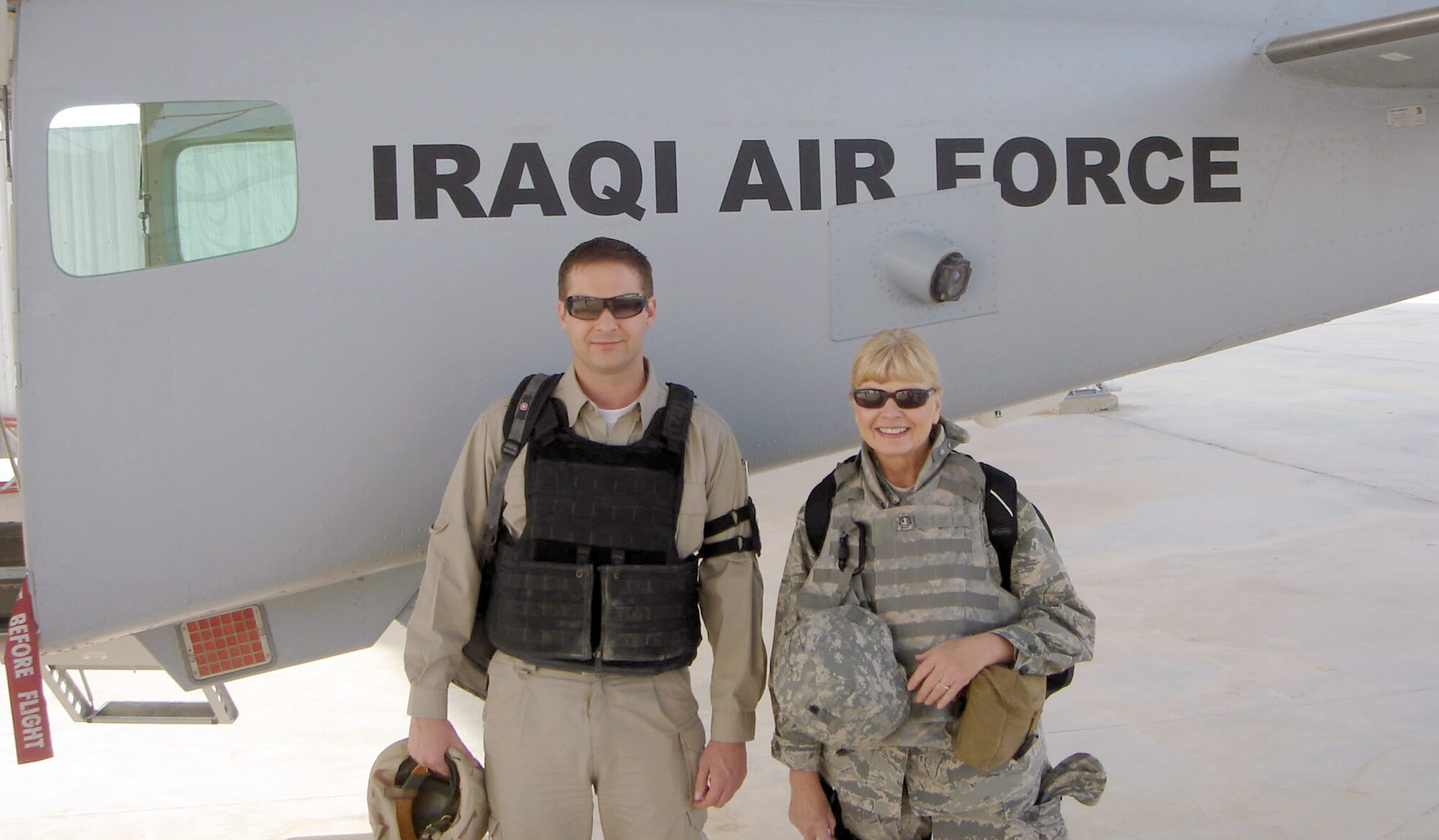 At Kirkuk Regional Air Base, Iraq, Laura MacKenzie and Johnathon Turner stand in front of an Iraqi air force trainer in 2009.  Ms. MacKenzie volunteered for the combat zone from the Defense Language Institute at Lackland Air Force Base, Texas, and was the chief of English language training for the Multi-National Security Transition Command-Iraq. Mr. Turner was an instructor pilot. (Courtesy photo)