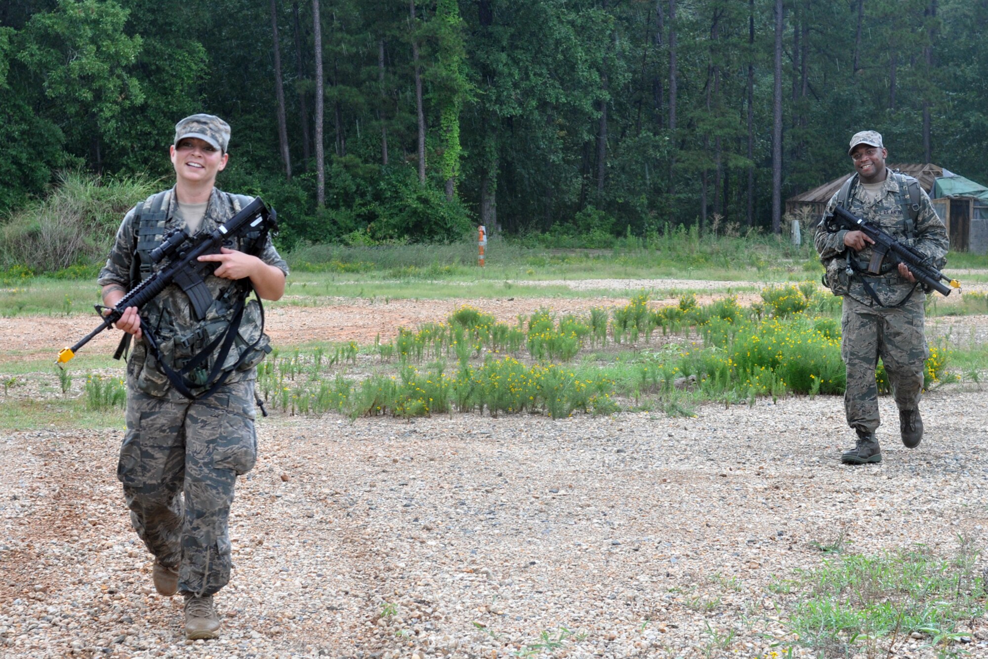 Tech. Sgt. Andrea Pepper, first squad, bravo fire team leader, and Airman First Class Jafus Sheridan, a first squad, bravo team member, stroll into base camp after a land navigation session during a torrential downpour at Barksdale Air Force Base, La., July 10, 2010. Both Airman are assigned to the 917th Security Forces Squadron at Barksdale and were involved in a field training exercise (FT) with other members of the 917 SFS. The exercise, which is usually held twice a year, helps keep training for the Airmen up to date in land navigation, building clearing, and other areas that keep the unit ready to deploy at a moment’s notice. (U.S. Air Force photo/Senior Airman Crystal Jordan)  